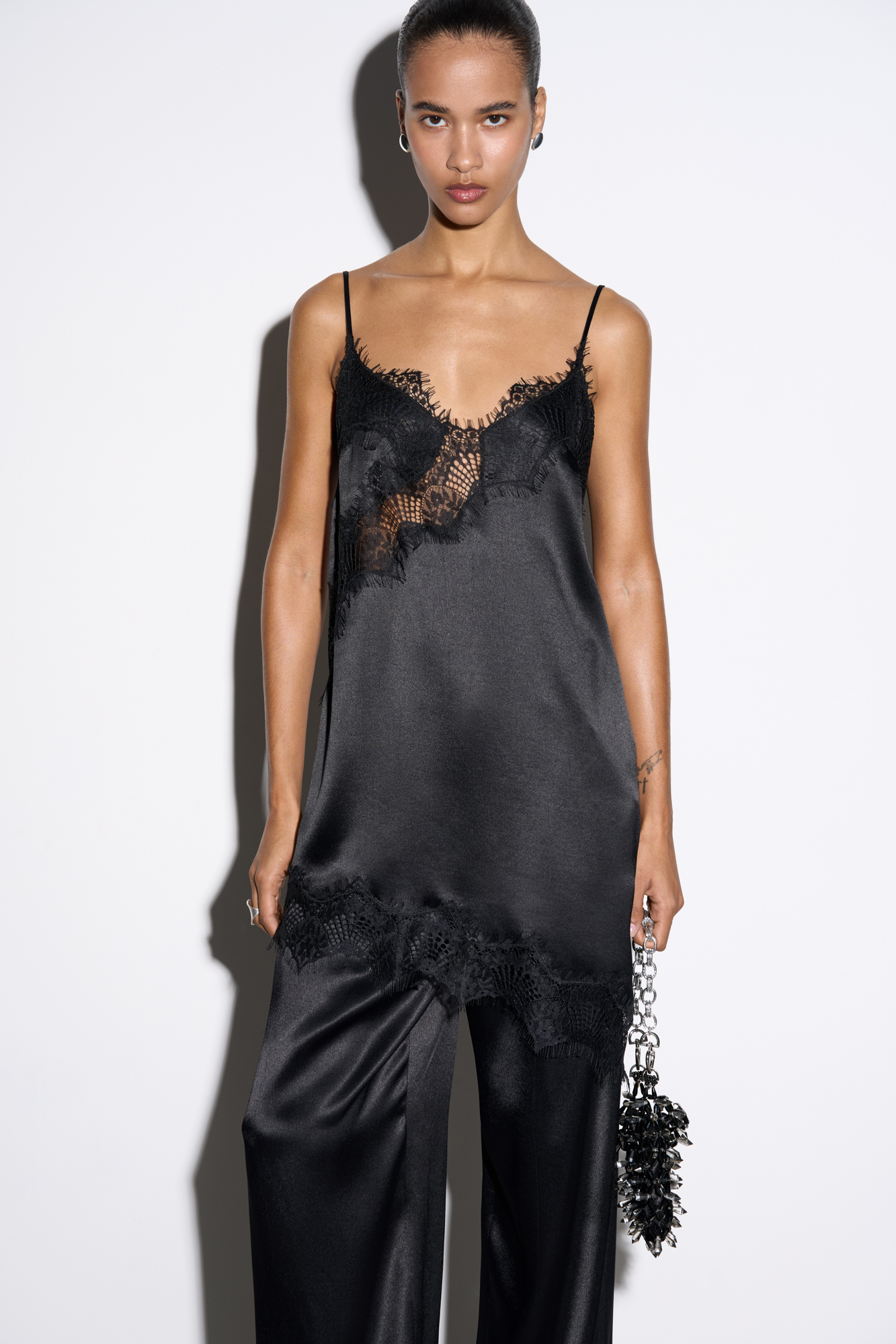 Платье-комбинация длины мини из 100% вискозы. Модель на тонких бретельках. Подол и лиф изделия декорированы тонким кружевом контрастного цвета.