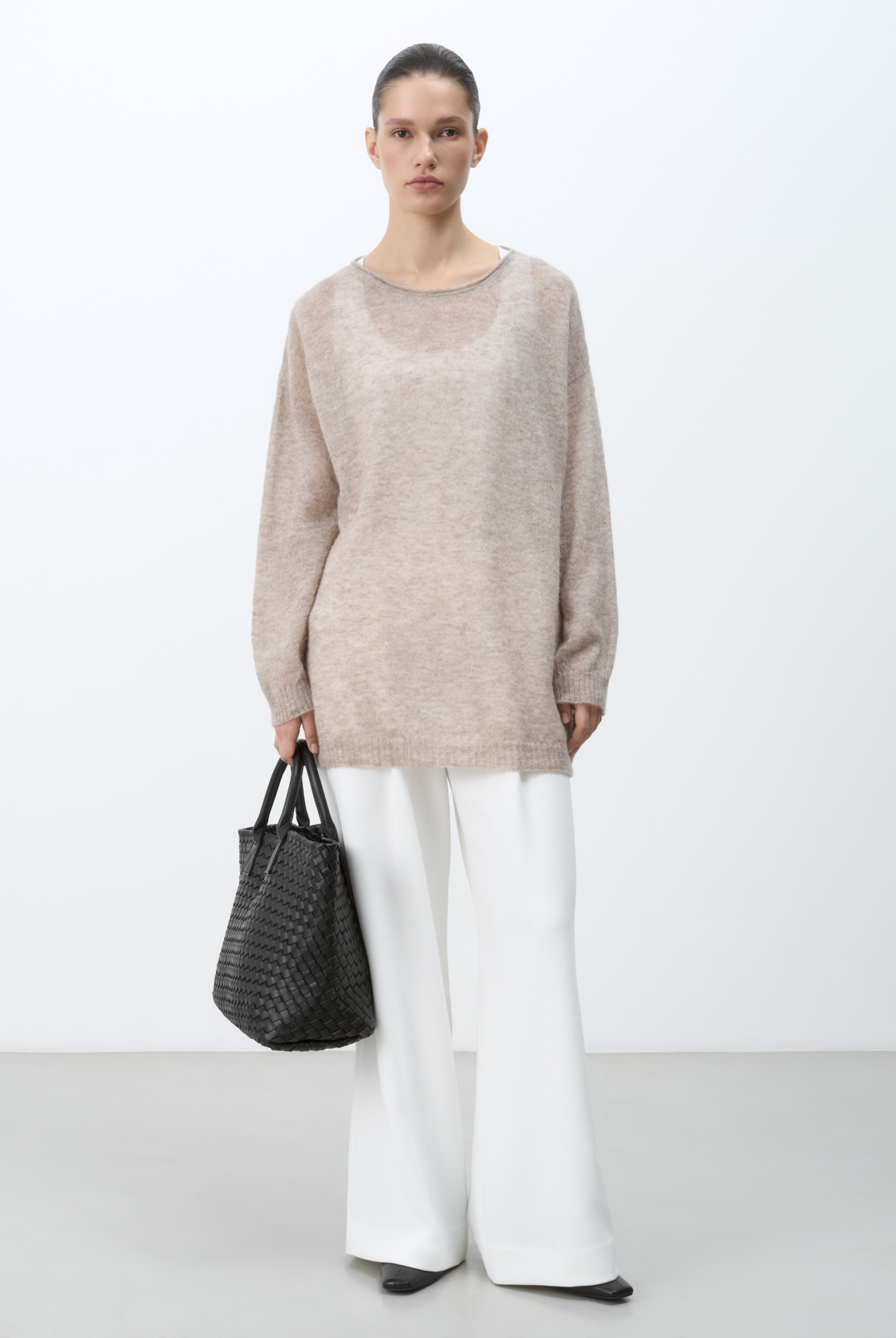 Длинный полупрозрачный трикотажный джемпер из мериносовой шерсти экстрафайн с добавлением шерсти альпака. Модель свободного силуэта, со спущенной линией плеч, длинными рукавами и неглубоким круглым вырезом горловины. Манжеты рукавов и низ изделия выполнены в рубчик.