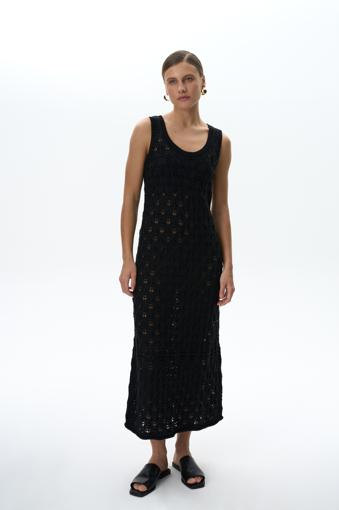 Облегающий ажурный сарафан из 100% хлопка. Модель с круглым вырезом горловины и небольшим расклешением юбки к низу. Изделие декорировано валиком с эффектом закручивания по краю подола. Края пройм и горловина выполнены в рубчик.