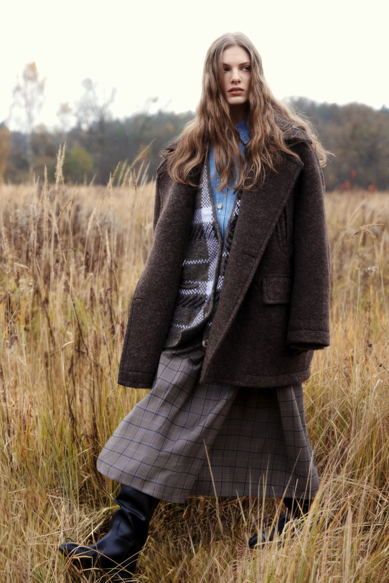 Юбка длины миди из шерсти в клетку. Модель А-силуэта с крупными косыми складками спереди. Застежка на молнию сзади. Изделие без подкладки.