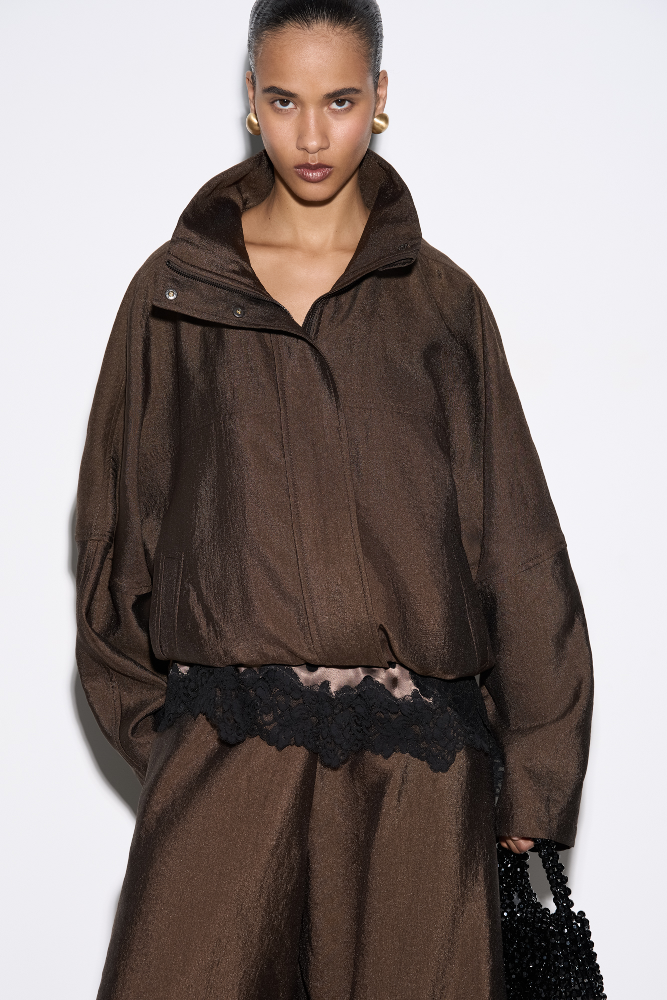 Бомбер из вискозы с воротником-стойкой. Модель свободного силуэта со спущенной линией плеча и боковыми карманами. Низ изделия выполнен на резинке. Застежка на молнию под планкой с кнопками.