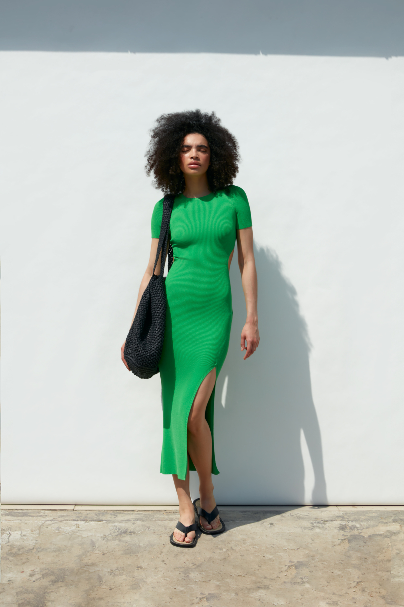 Облегающее трикотажное платье длины миди из вискозы. Модель приталенного силуэта, с короткими рукавами, круглым вырезом горловины, вырезом на спине и высоким разрезом сбоку.