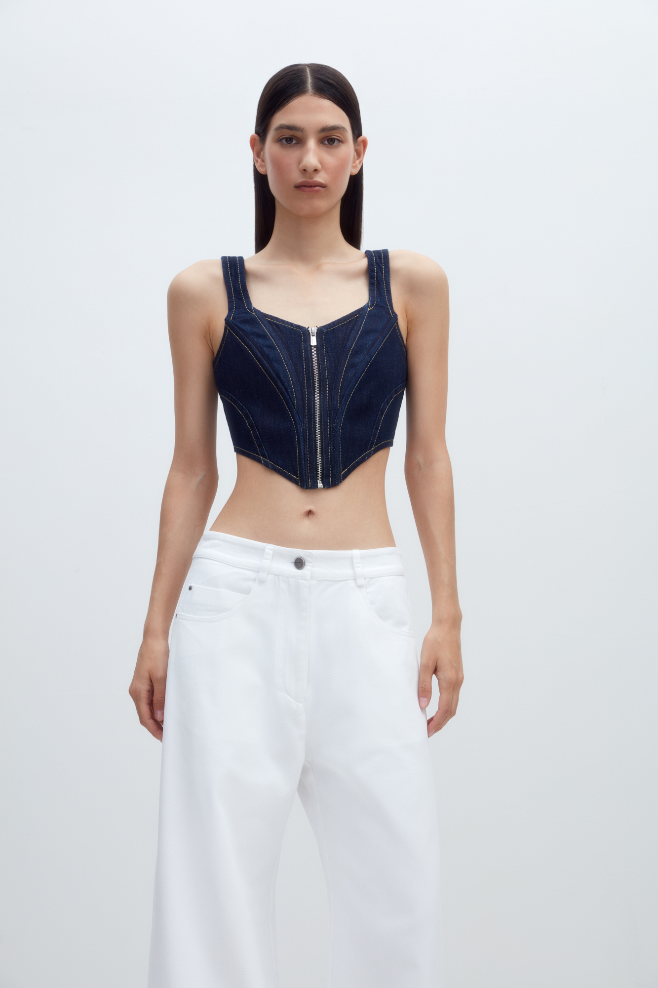 Джинсовый корсет из 100% хлопка с застежкой на молнии и лентой-завязкой на спинке. Дополнить образ можно джинсами и джинсовкой.