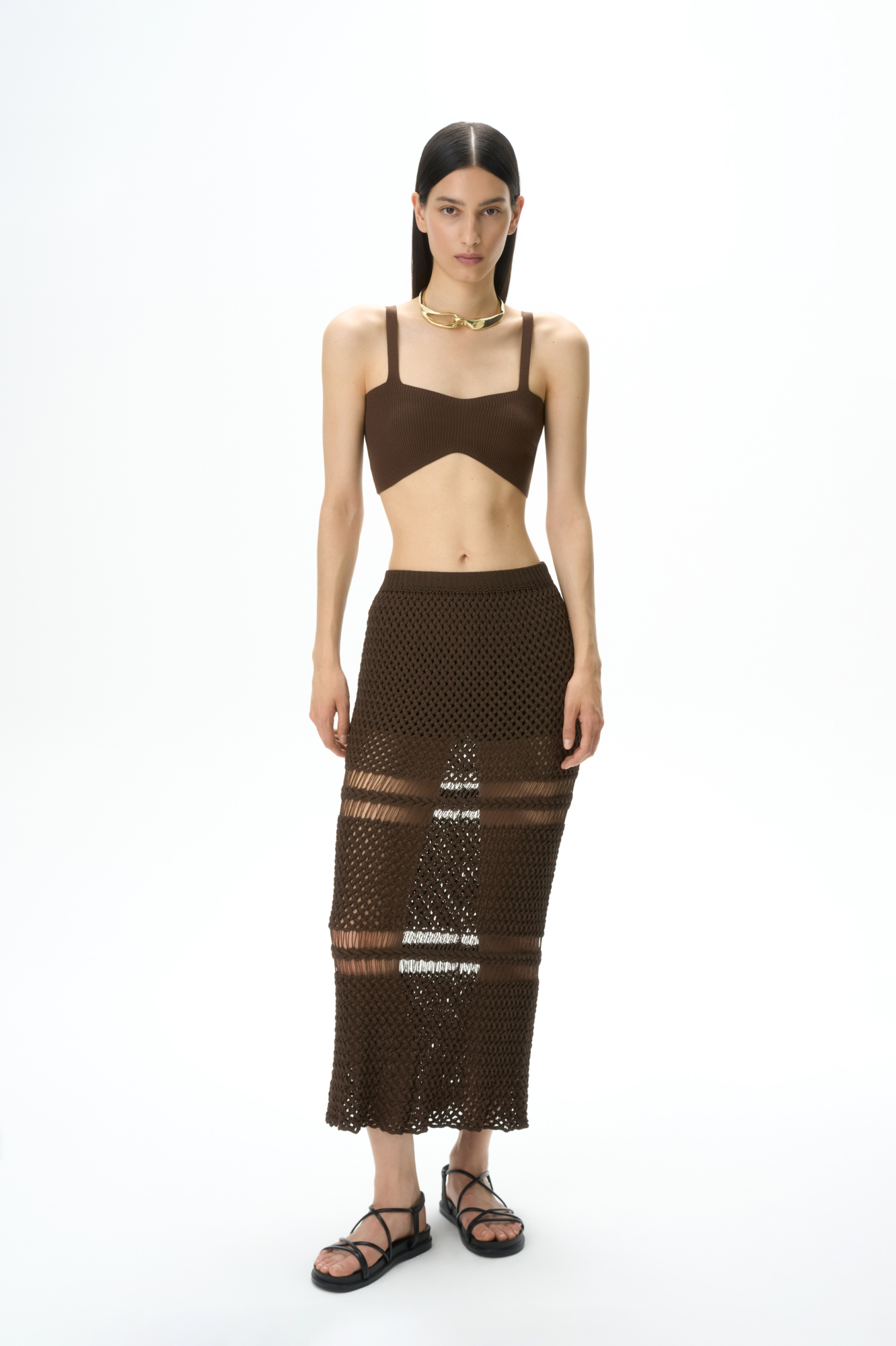 Трикотажная юбка длины макси. Модель приталенного силуэта, выполненная сложным ажурным переплетением с протяжками. 