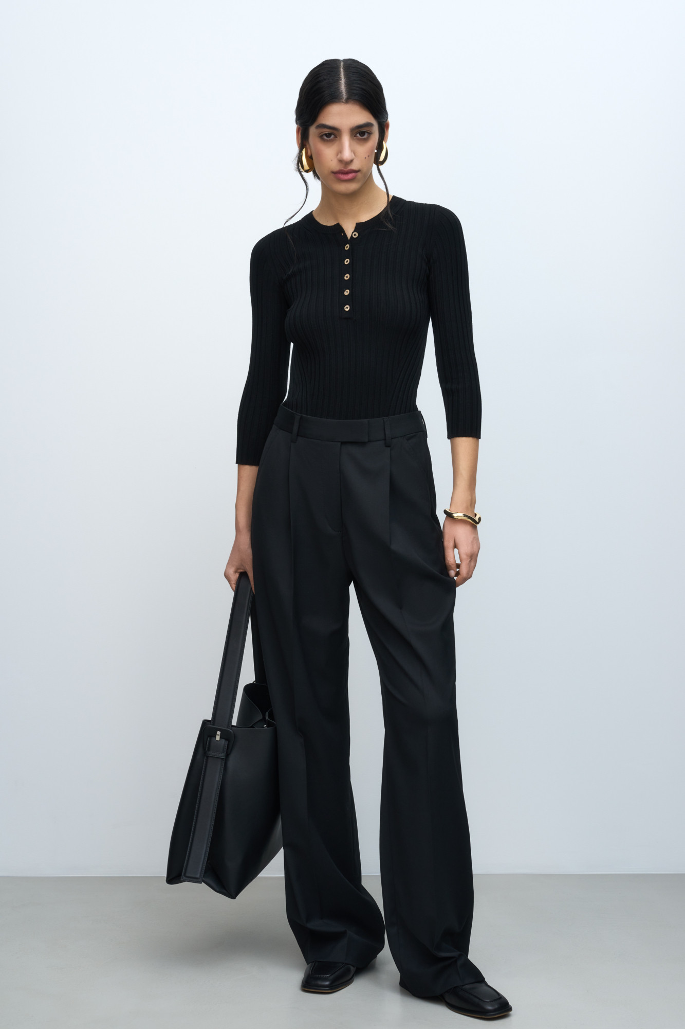 Трикотажный топ из вискозы в широкий рубчик. Модель с рукавами 3/4 и вырезом горловины с планкой на пуговицах, создающим V-образный вырез.