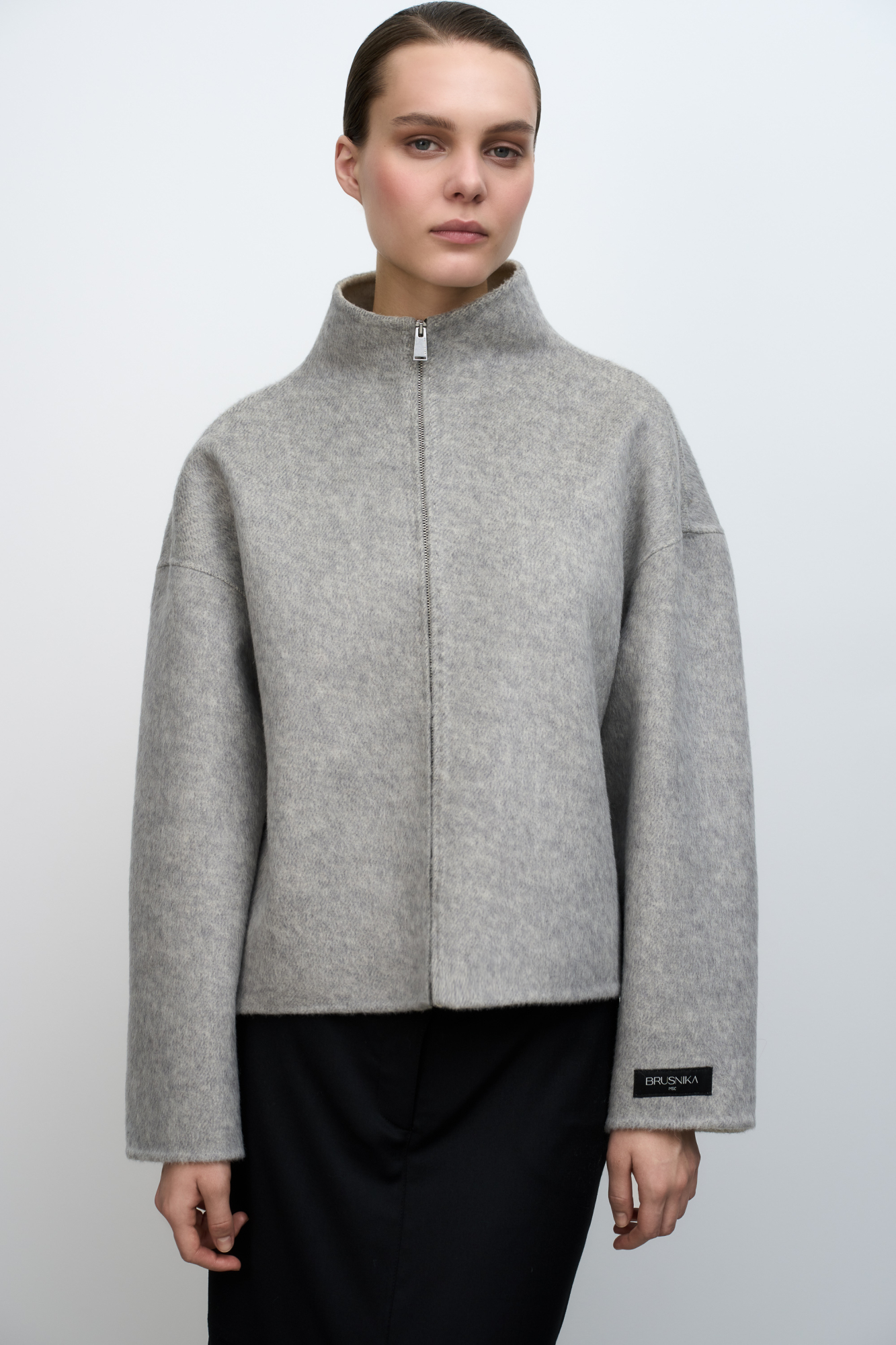 Жакет из шерсти с воротником-стойкой. Модель свободного силуэта со спущенной линией плеча и брендированным ярлыком на рукаве и спине. Застежка на молнию. Без подкладки. 
