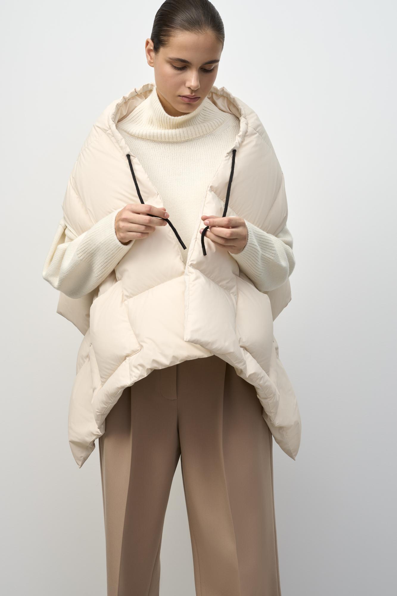 Палантин-жилет с накладными карманами. Регулируемая кулиска на вороте. Изделие выполнено с прорезями для рук на молнии. Наполнитель натуральный пух 90% перо 10%.