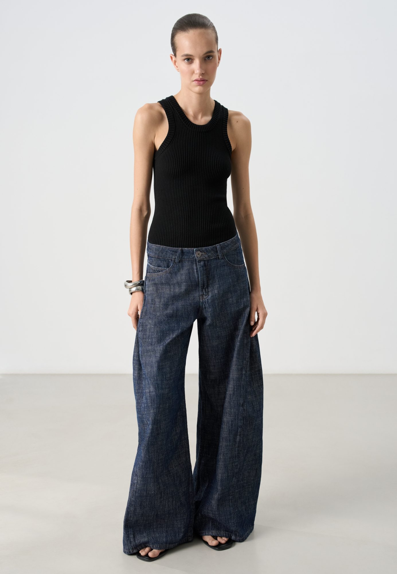 Широкие джинсы из 100% хлопка. Модель свободного кроя с защипами по бокам, шлевками на поясе для ремня и застежкой на молнию и пуговицу.