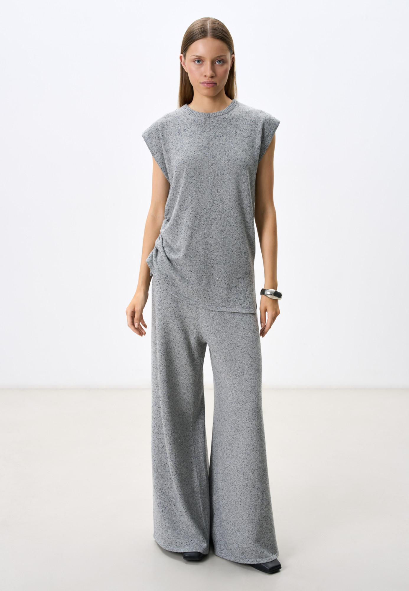 Трикотажные меланжевые брюки из мягкой шерсти с добавлением шелка и вискозы. Модель прямого силуэта с широким поясом на кулиске. Можно дополнить жилетом из такой же пряжи.