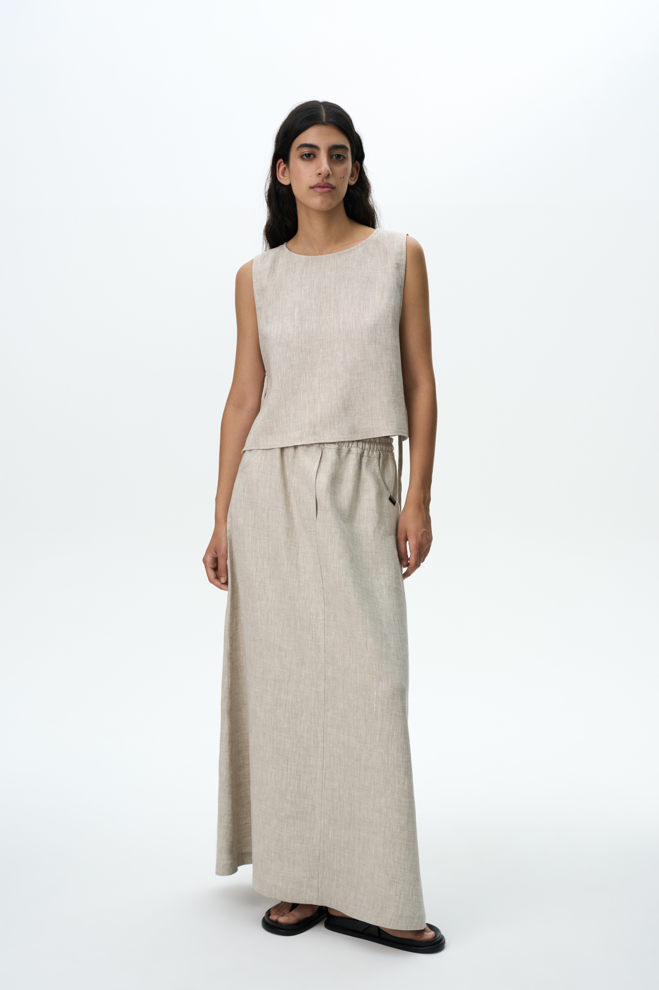 Юбка длины макси из 100% льна. Модель свободного силуэта с эластичным поясом на кулиске и боковыми карманами. Дополнить образ можно топом в том же стиле.