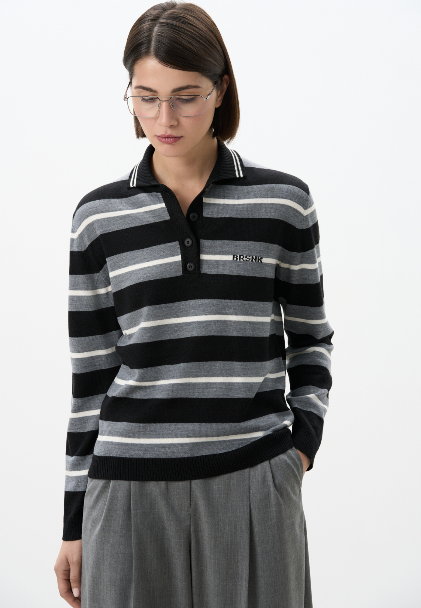 Трикотажный джемпер из шерсти в полоску. Модель свободного силуэта, с длинными рукавами, воротником поло на пуговицах и брендированным жаккардом на груди. Манжеты, воротничок и низ изделия выполнены в рубчик.