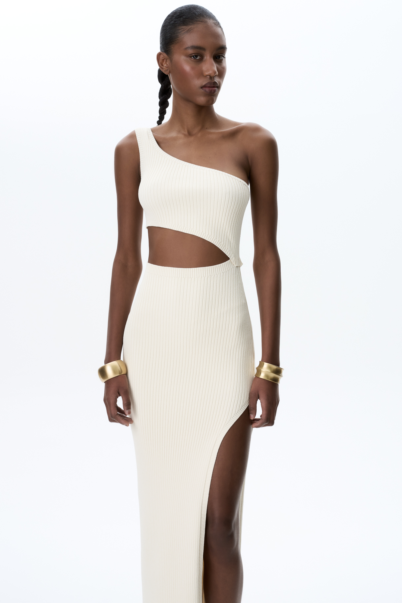 Трикотажное платье длины миди из вискозы в рубчик. Модель приталенного силуэта асимметричного кроя, с акцентным вырезом на талии, высоким разрезом на бедре и широкой бретелькой на одно плечо.