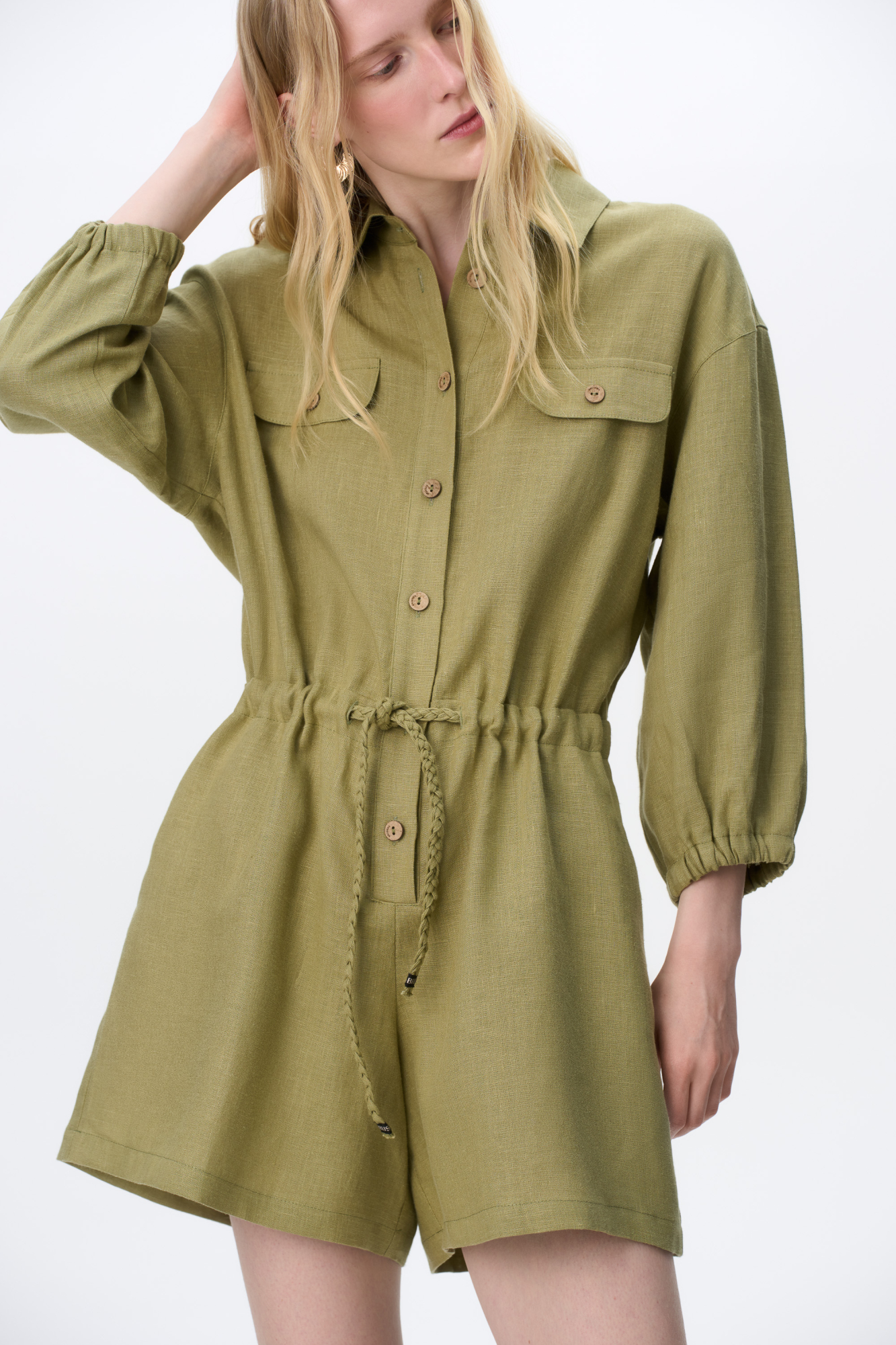 Комбинезон из 100% льна. Модель с рубашечным верхом, отложным воротником, накладными карманами на груди, длинными рукавами и застежкой на пуговицы. Регулируемая кулиска на поясе. 