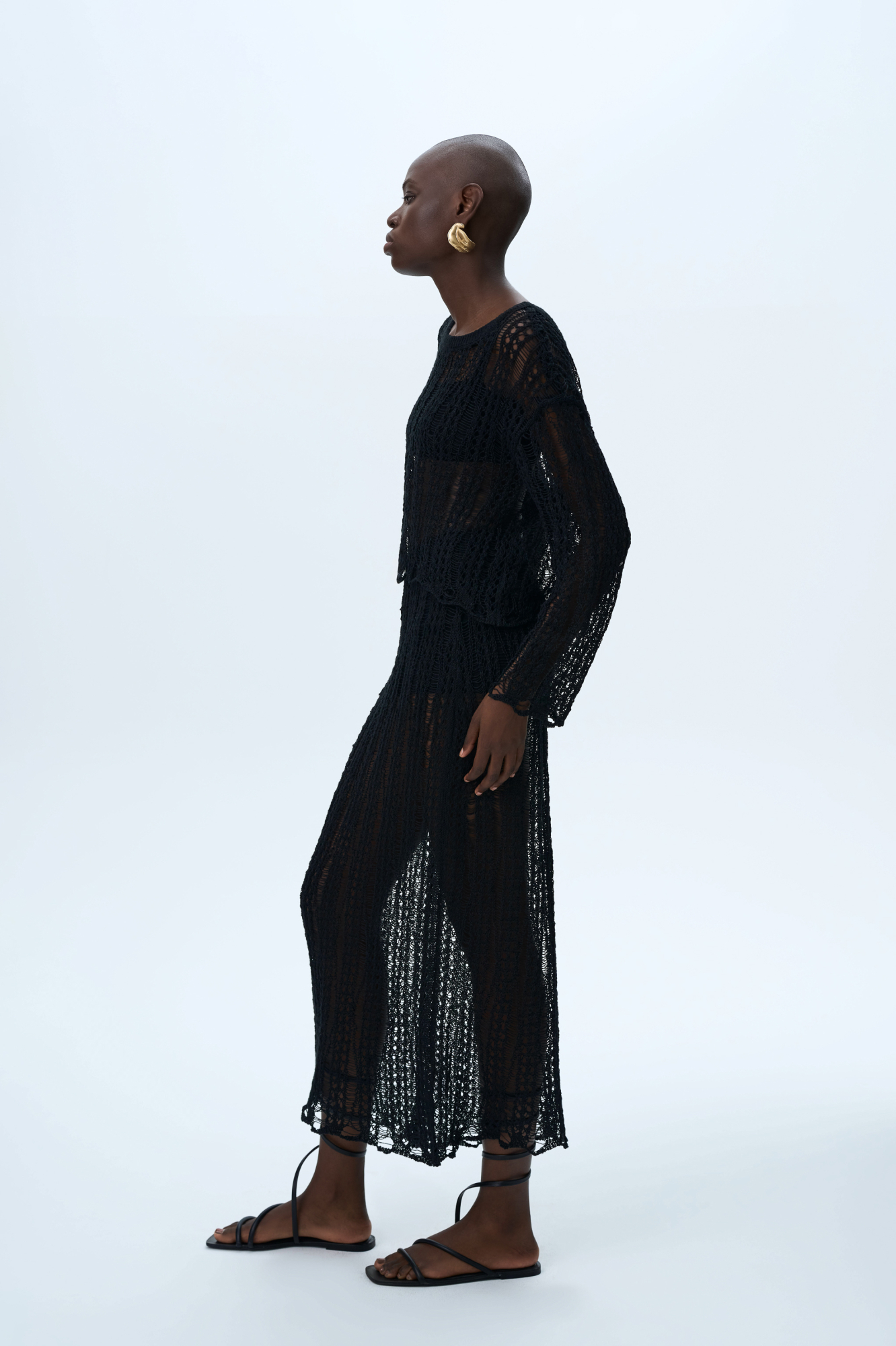 Полупрозрачная ажурная юбка. Модель приталенного силуэта длины миди с эластичным поясом в рубчик. Дополнить образ можно джемпером в таком же стиле.