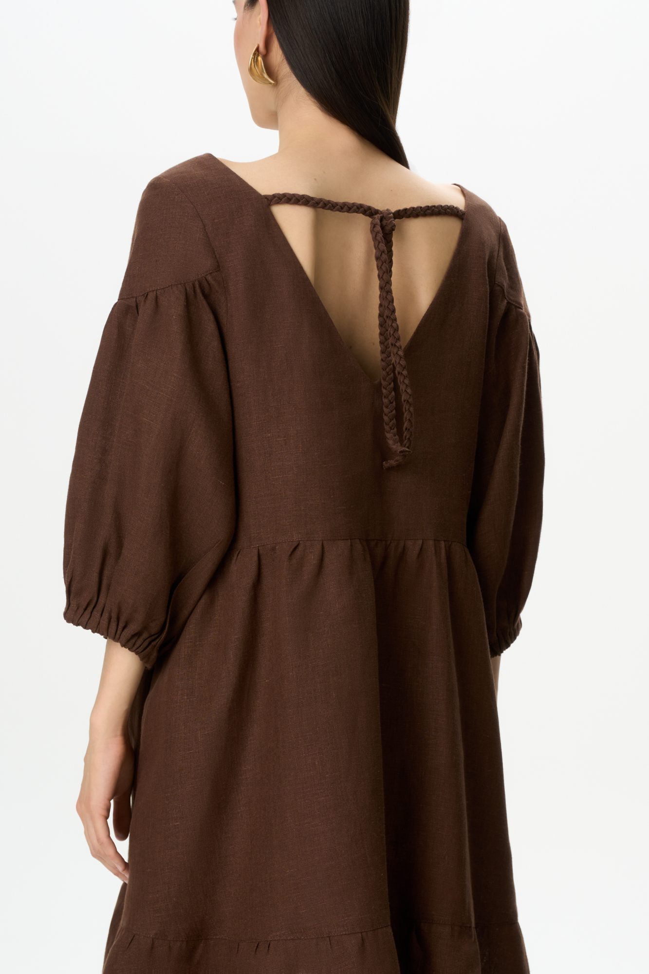 Короткое платье из 100% льна с расклешением от талии и широким асимметричным воланом внизу. Модель свободного кроя с коротким рукавом на резинке и V-образным вырезом с завязками на спине.