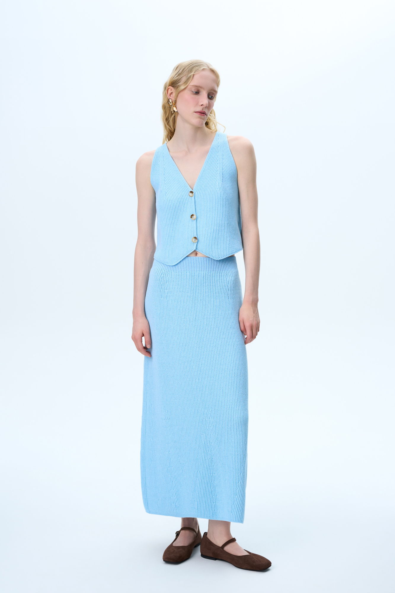 Трикотажная юбка длины макси из хлопка с добавлением вискозы. Модель свободного силуэта с эластичным поясом в рубчик. Дополнить образ можно жилетом в таком же стиле.