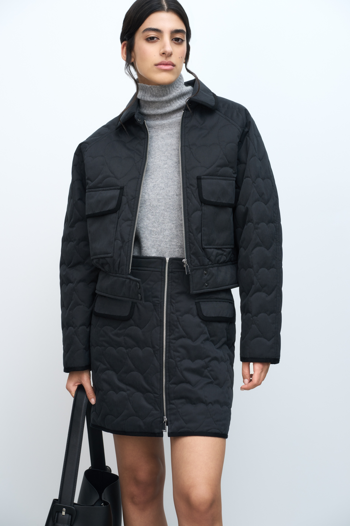 Стеганая юбка длины мини. Модель приталенного силуэта с карманами спереди. Стежка выполнена в виде сердец.