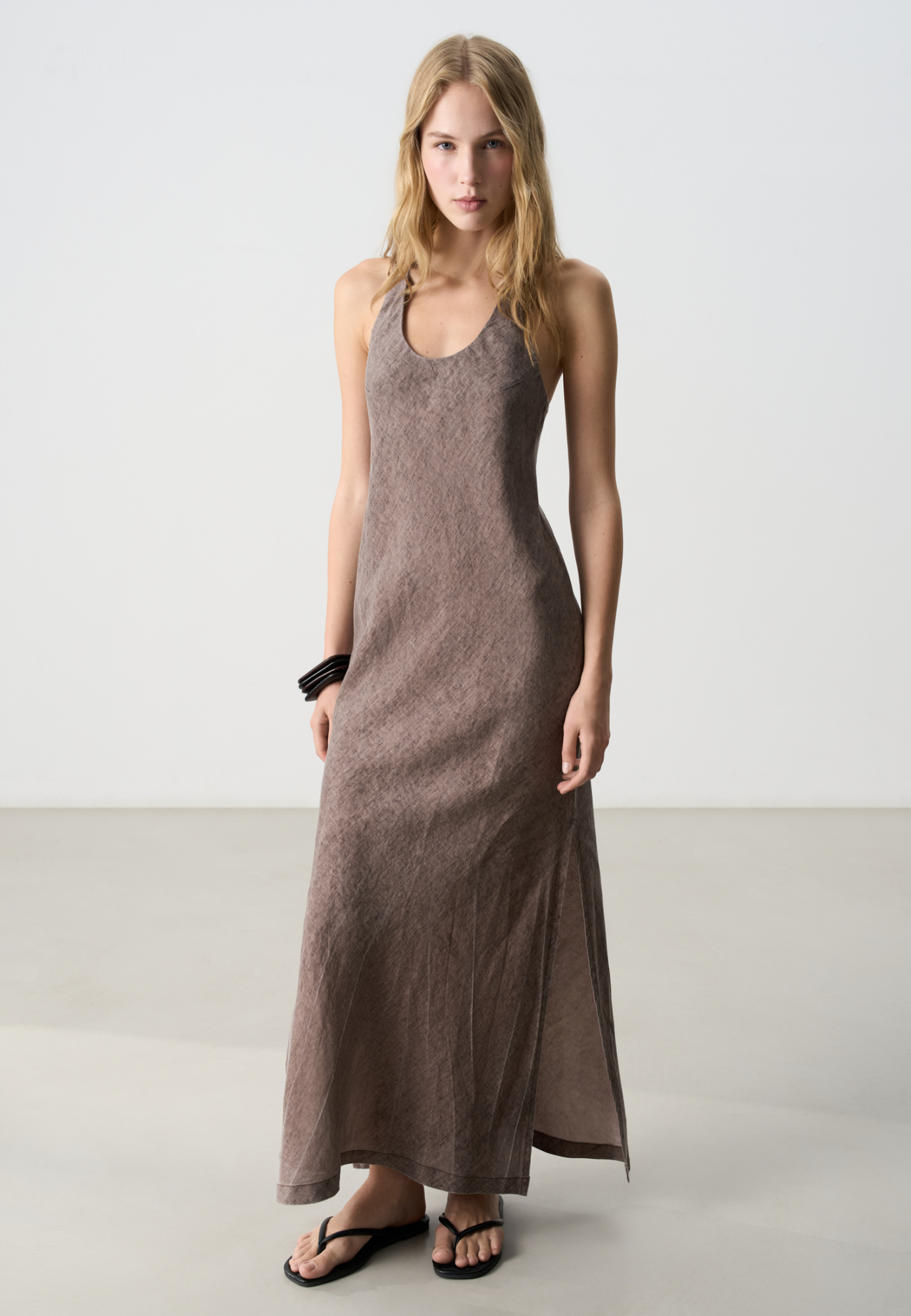 Сарафан из 100% льна длины макси. Модель свободного силуэта, без рукавов, на широких бретельках с перекрутом на спине, U-вырезом и симметричными разрезами на юбке по бокам.