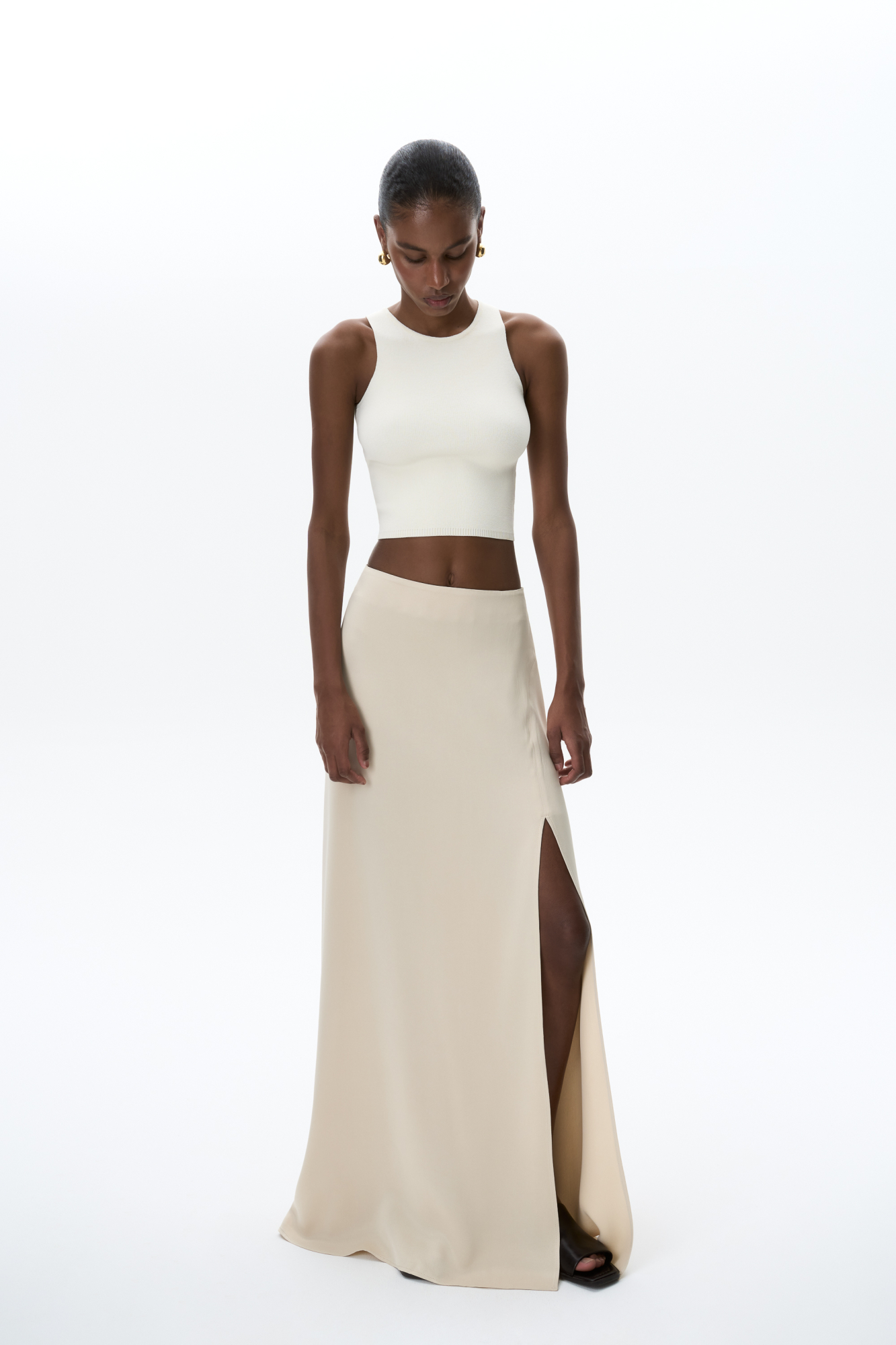 Трикотажный укороченный топ из вискозы. Модель без рукавов с круглым вырезом горловины.