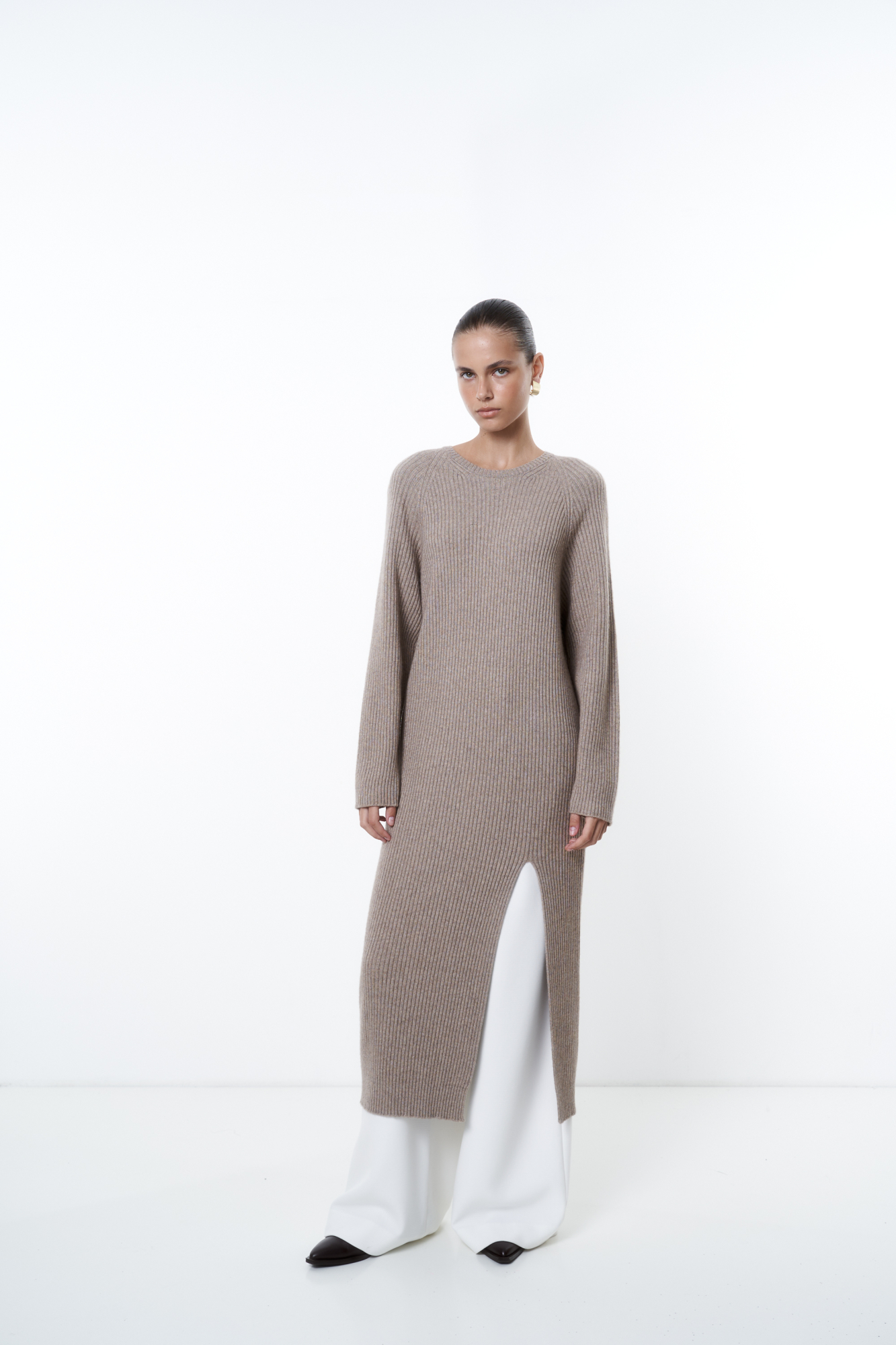 Трикотажное платье из шерсти и кашемира. Модель свободного силуэта в широкий рубчик с разрезом спереди и спущенной линией плеча. 