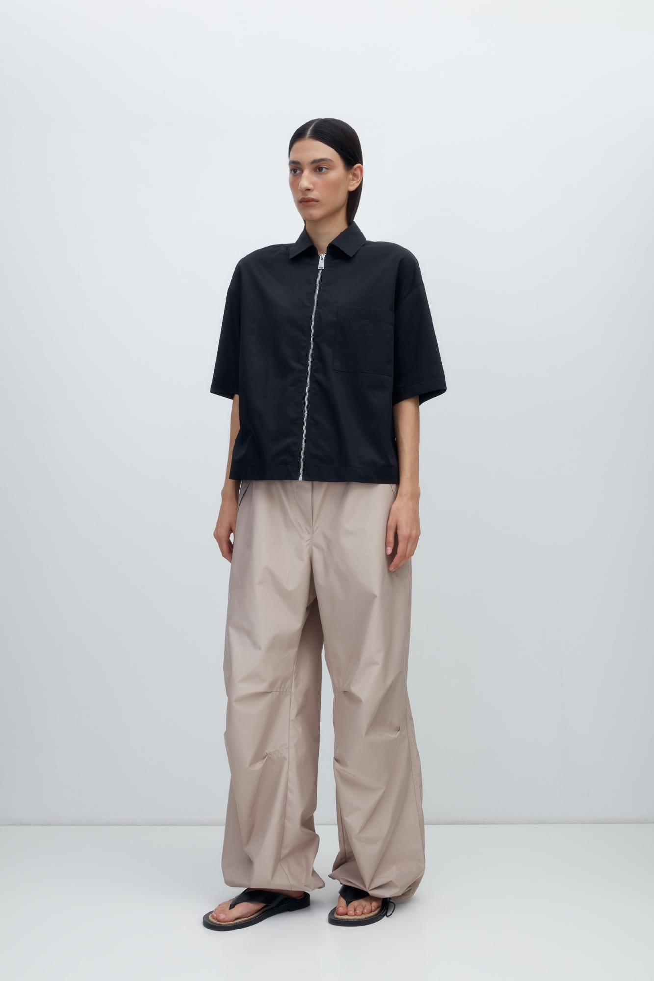 Рубашка из хлопка с добавлением полиамида. Модель прямого кроя, со спущенной линией плеч, отложным воротником, короткими рукавами, накладным карманом на груди и застежкой на молнию.