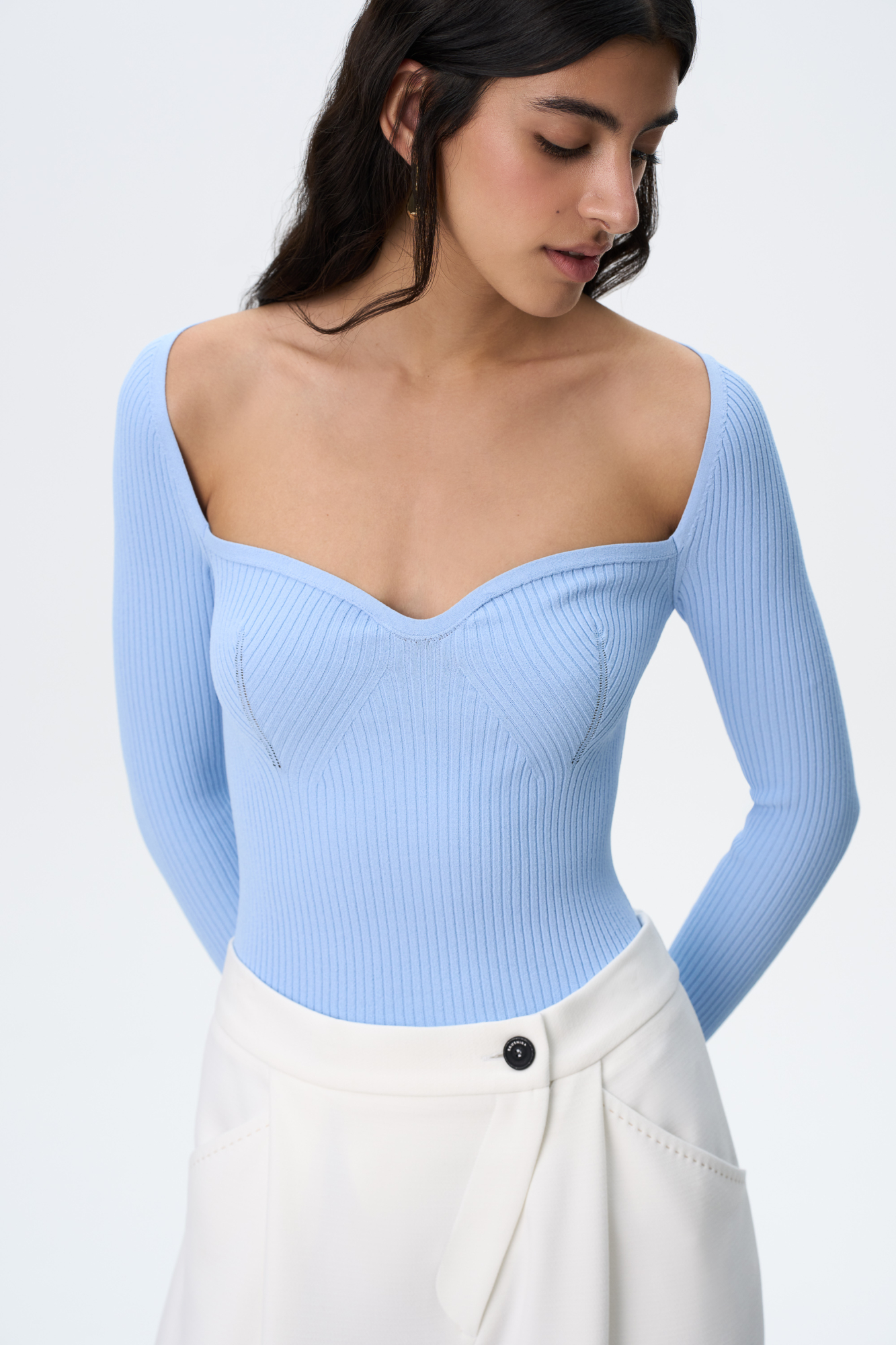 Трикотажный топ из вискозы. Модель приталенного силуэта с вывязанным открытым декольте, длинными рукавами и разрезом на манжетах.