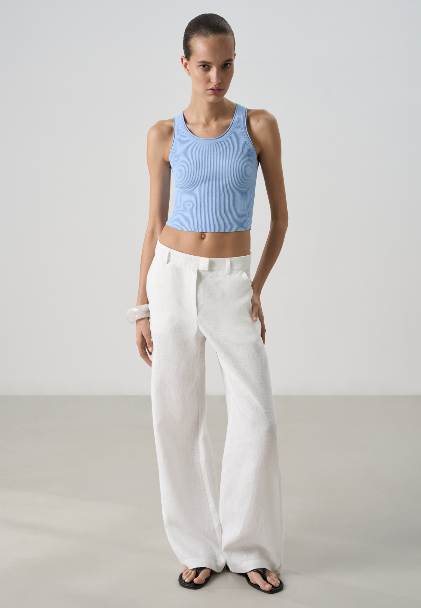 Брюки из 100% льна. Модель прямого кроя с карманами и шлевками на поясе для ремня. Изделие декорировано отстрочкой контрастного цвета.