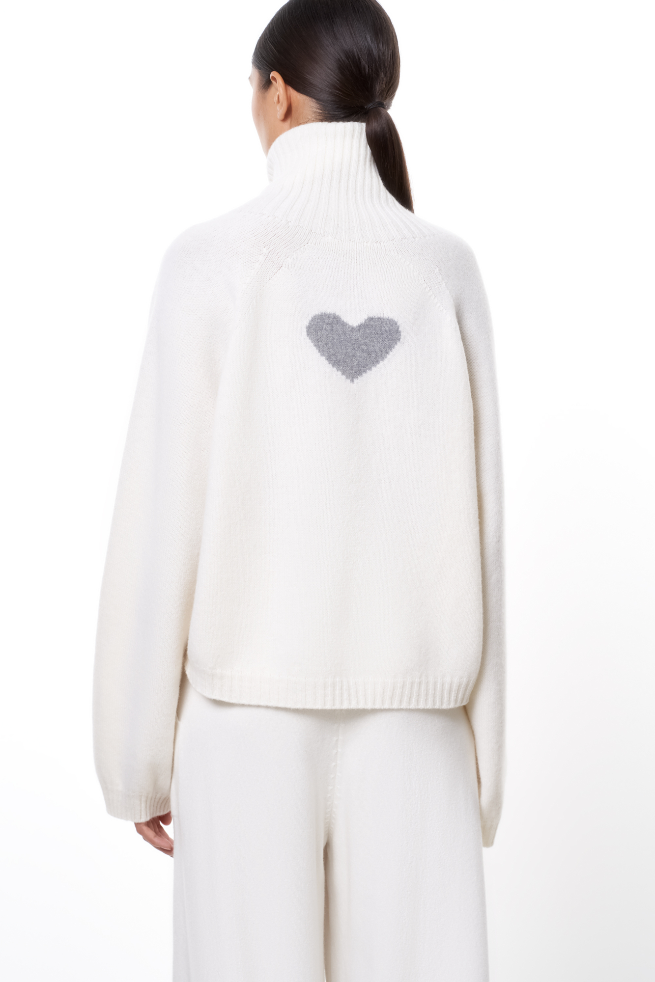 Трикотажный джемпер из шерсти с добавлением кашемира. Модель с высоким воротником в рубчик, спущенной линией плеча и жаккардовым рисунком в виде сердца на спине.