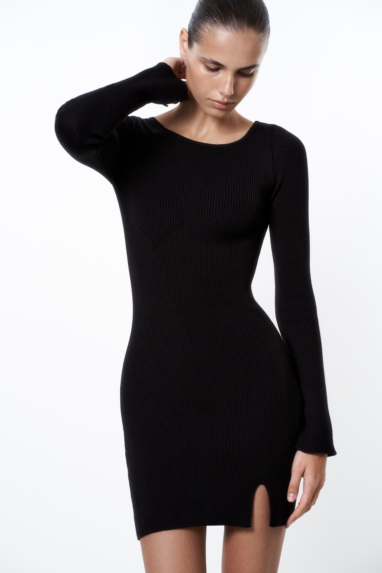 Трикотажное мини платье из шерсти с добавлением вискозы. Модель по фигуре с круглым вырезом горловины, длинными рукавами и невысоким разрезом спереди. Изделие декорировано объемными вытачками, имитирующими бюстье. 