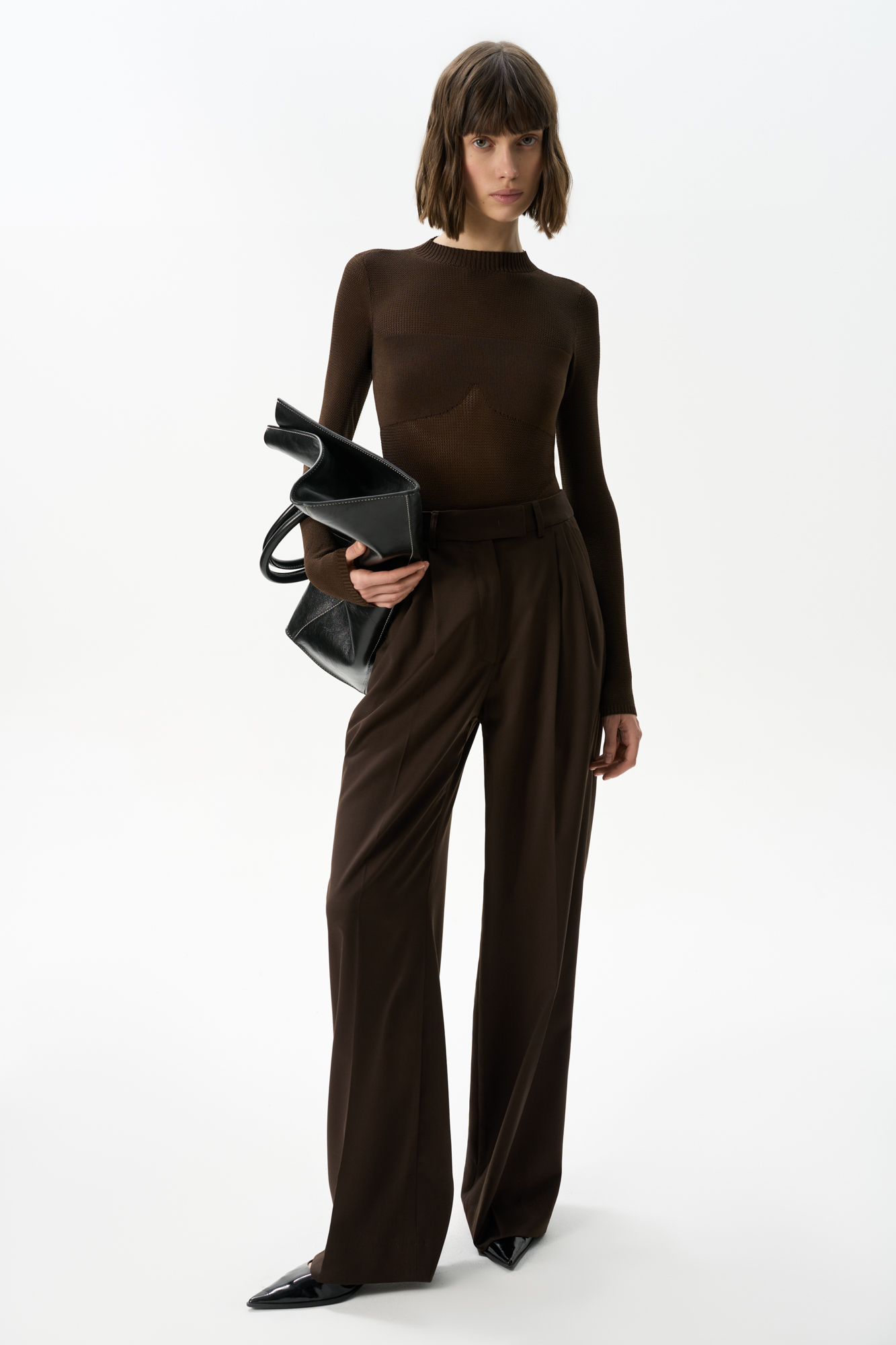 Трикотажное боди из вискозы. Модель с длинным рукавом и невысоким воротником, края изделия в рубчик. Застежка на бельевые крючки. Модель выполнена в комбинированной вязке: сетку и гладью в мелкий рубчик в области груди и низа изделия.