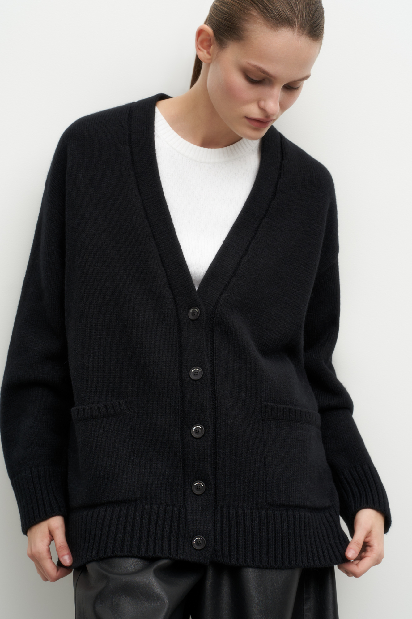 Трикотажный кардиган из шерсти альпака. Модель свободного силуэта с V-образным вырезом и накладными карманами. Края изделия в рубчик.