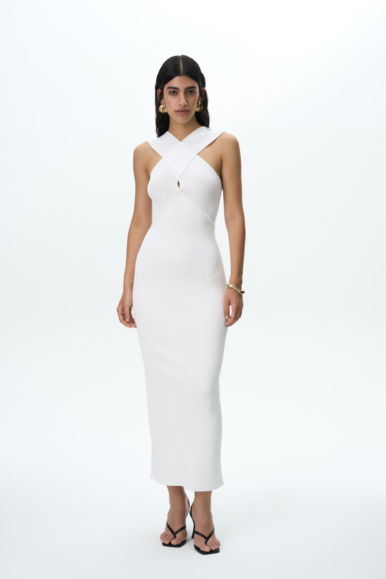 Облегающее длинное трикотажное платье в мелкий рубчик. Изделие декорировано вывязанной перекрещенной деталью на лифе и небольшим разрезом сзади.