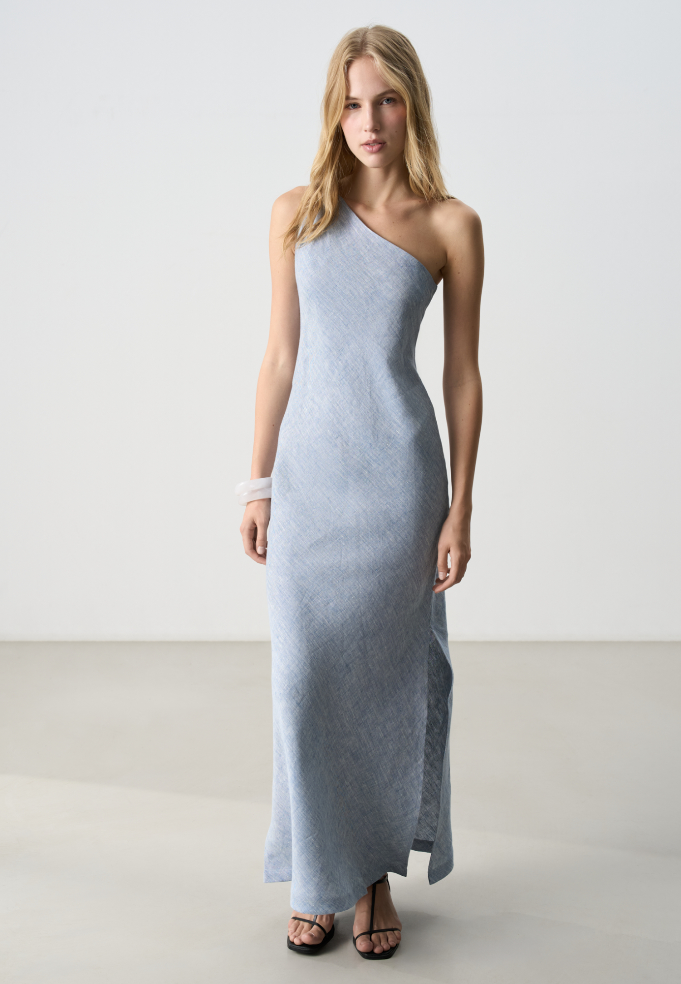 Платье длины макси из 100% льна. Модель асимметричного кроя, с перекрученной лямкой на одно плечо. Разрез сбоку.