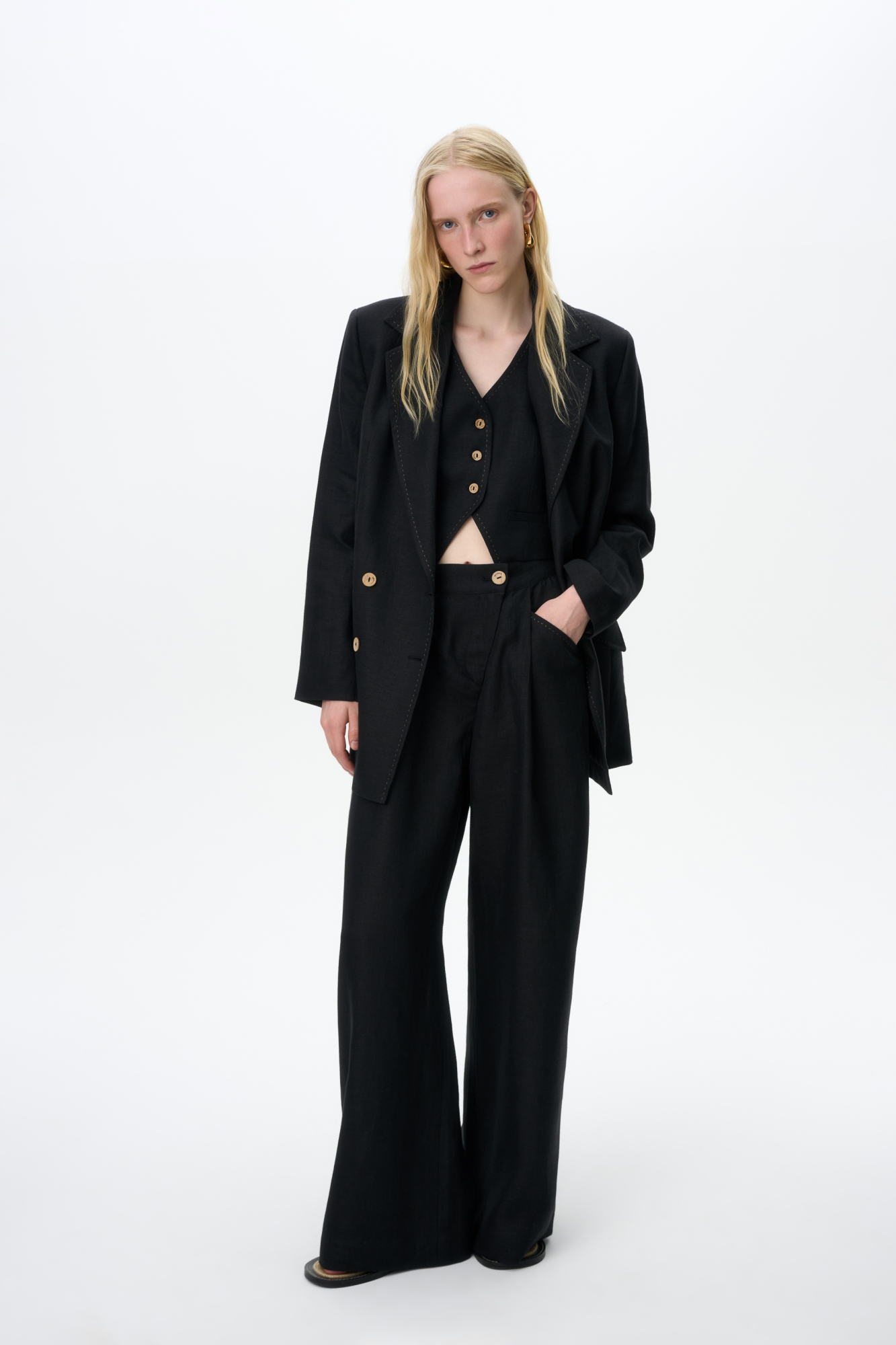 Брюки из 100% льна. Модель прямого кроя, с высокой посадкой, косой застежкой на пуговицу и молнию, боковыми карманами.