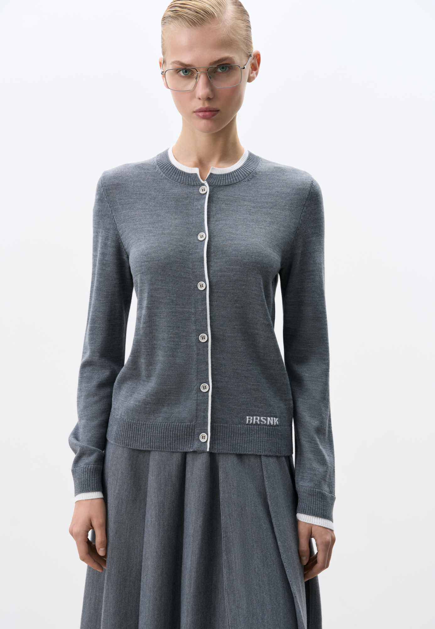 Трикотажный кардиган из шерсти с добавлением акрила. Модель свободного силуэта с контрастными манжетами и воротничком. Изделие декорировано брендированным жаккардом. Застежка на пуговицы.