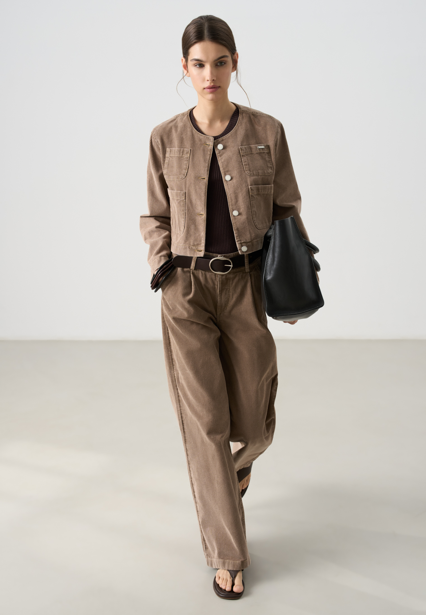 Вельветовые брюки из 100% хлопка с высокой посадкой. Модель с широким поясом и шлевками для ремня, сзади пояс выполнен на резинке. Застежка на две металлические пуговицы и молнию. Дополнить образ можно жакетом.