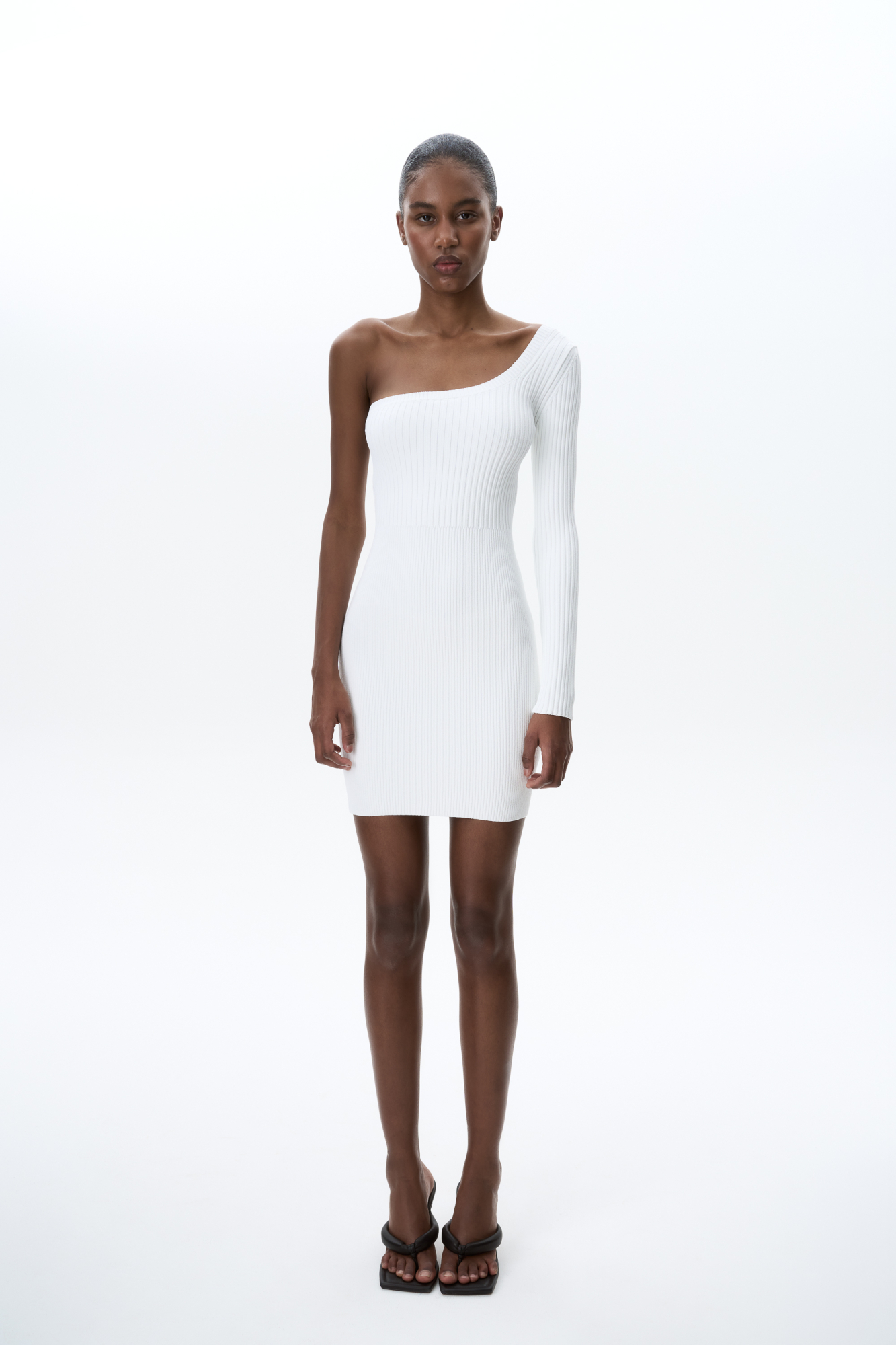 Трикотажное платье длины мини из вискозы. Модель приталенного силуэта с одним рукавом и открытым плечом.