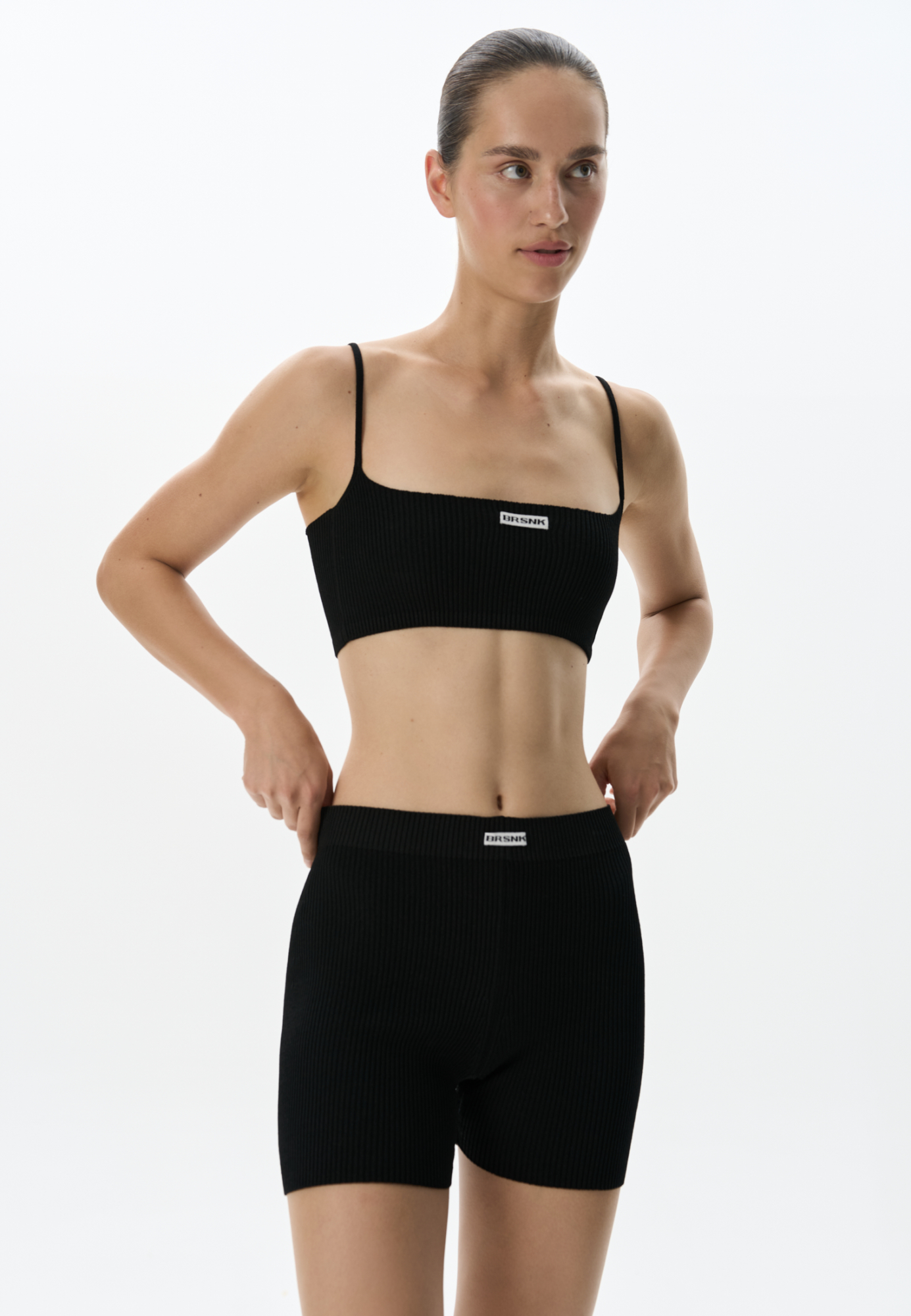 Трикотажный короткий топ из вискозы в спортивном стиле. Модель выполнена в рубчик на тонких бретельках. Брендированный жаккард на груди. Дополнить образ можно шортами в таком же стиле. 