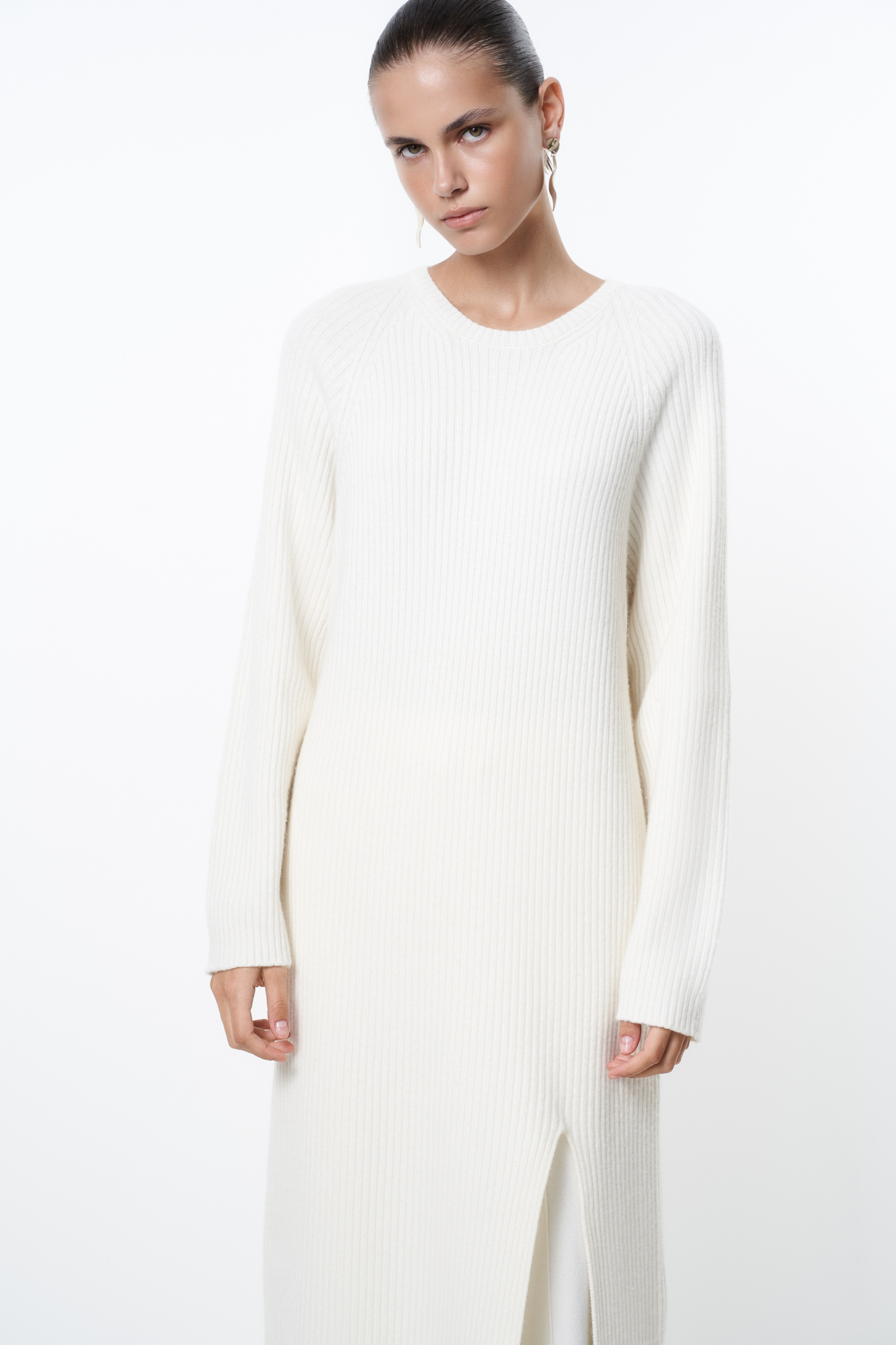 Трикотажное платье из шерсти и кашемира. Модель свободного силуэта в широкий рубчик с разрезом спереди и спущенной линией плеча. 