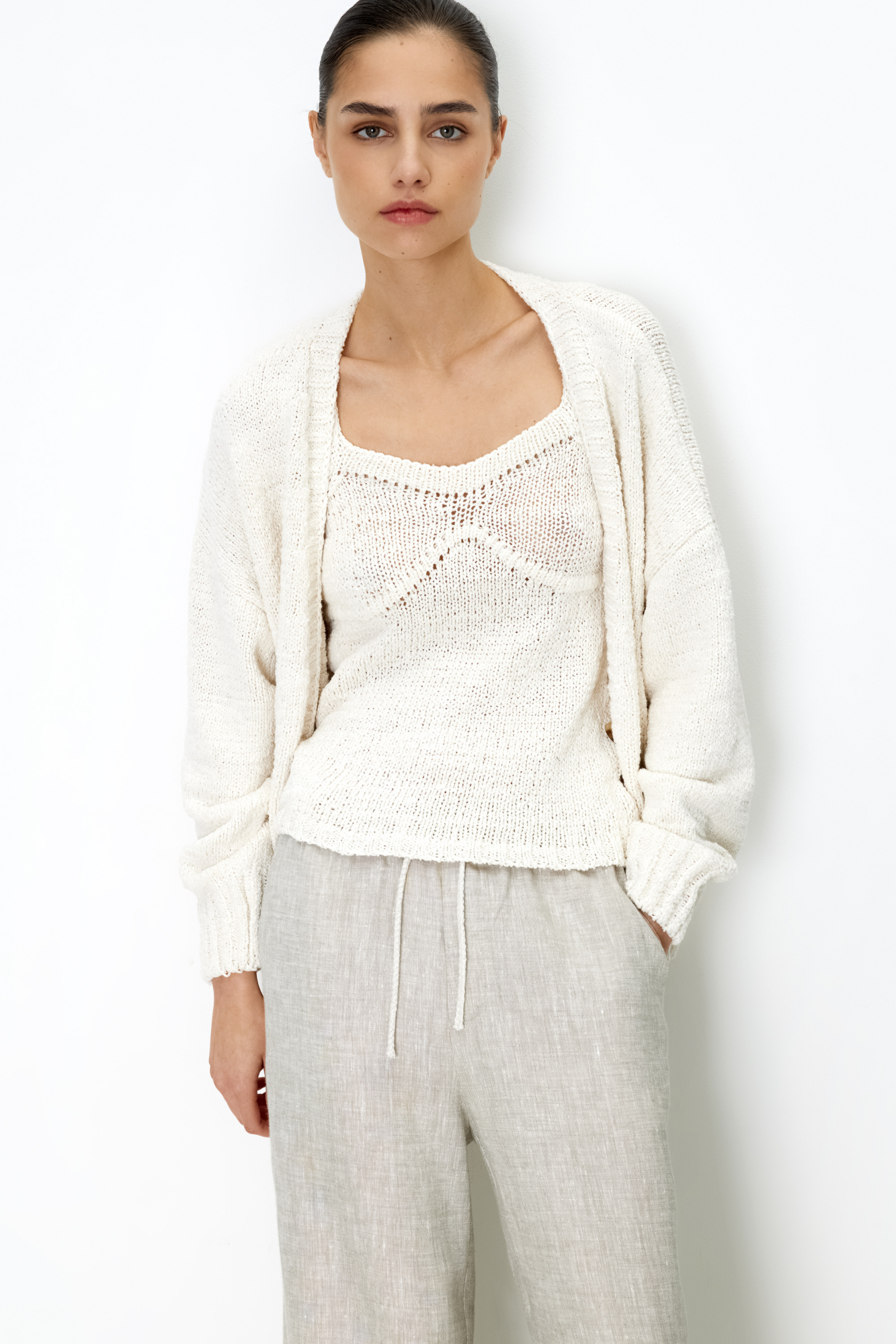 Трикотажный топ из хлопка с добавлением акрила. Модель на тонких бретелях с вывязанным лифом.