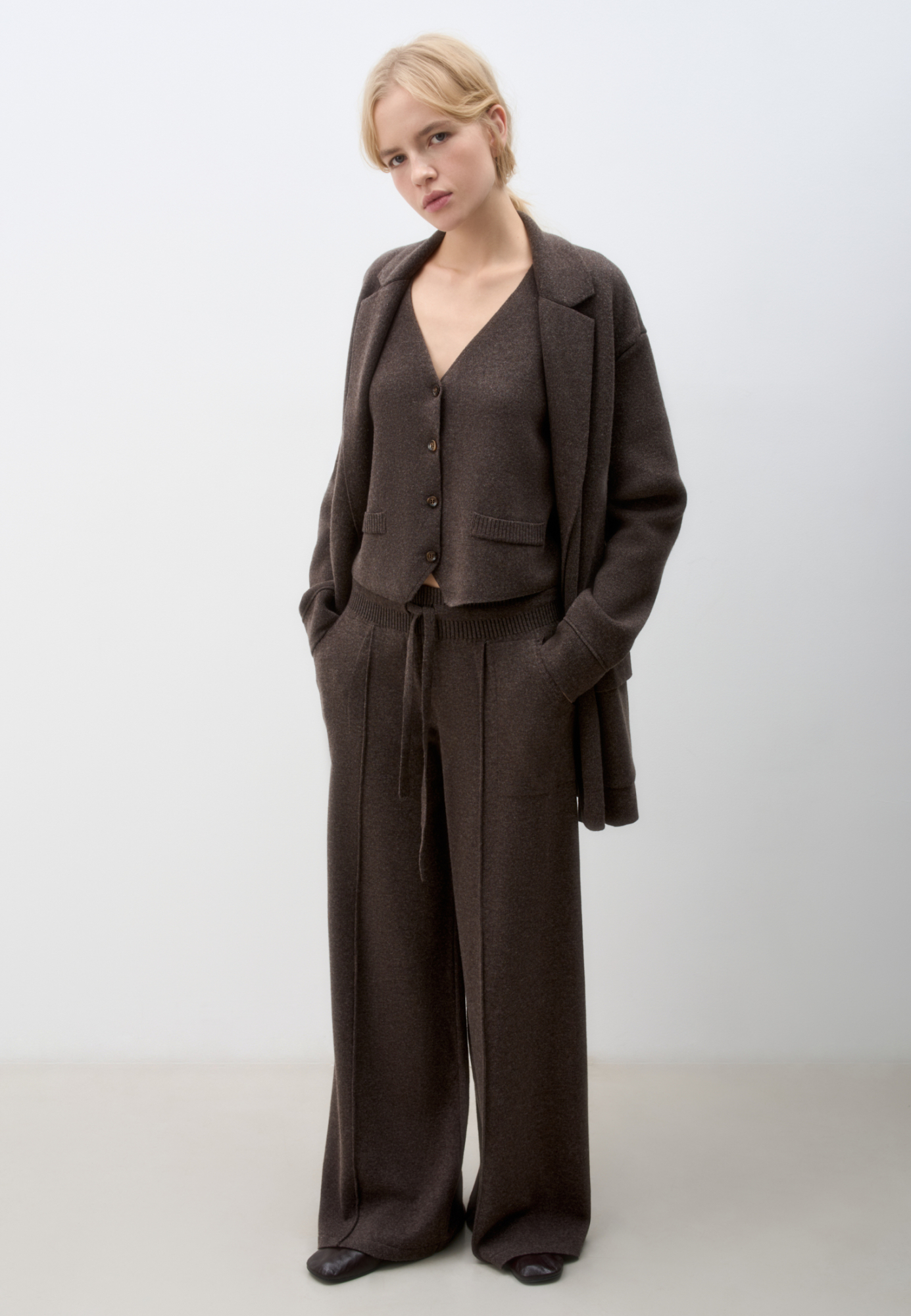 Трикотажные брюки из смесовой шерсти. Модель свободного силуэта со средней посадкой, боковыми карманами и стрелками. Эластичный пояс на кулиске в рубчик.