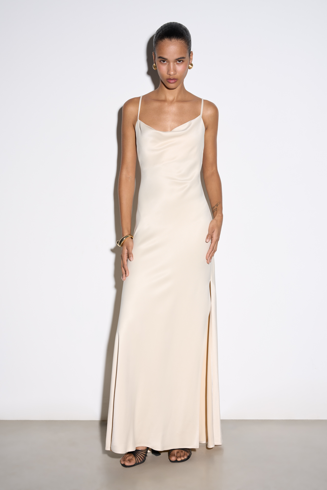 Атласное платье-комбинация длины миди из 100% вискозы. Модель приталенного силуэта, с высоким разрезом сбоку и открытой спиной,&nbsp;&nbsp;Изделие выполнено на тонких регулируемых бретелях. 