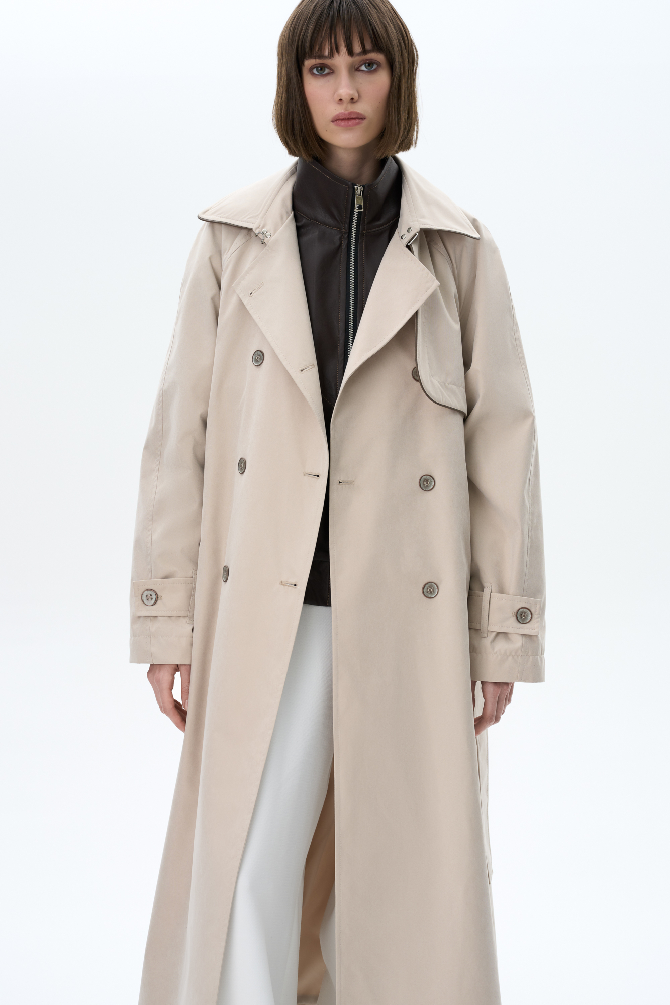 Двубортный тренч свободного кроя с отложным воротником, застежка на вороте, асимметричная отлетная кокетка и боковые карманы. В комплекте съемный пояс из основного материала. На подкладке.