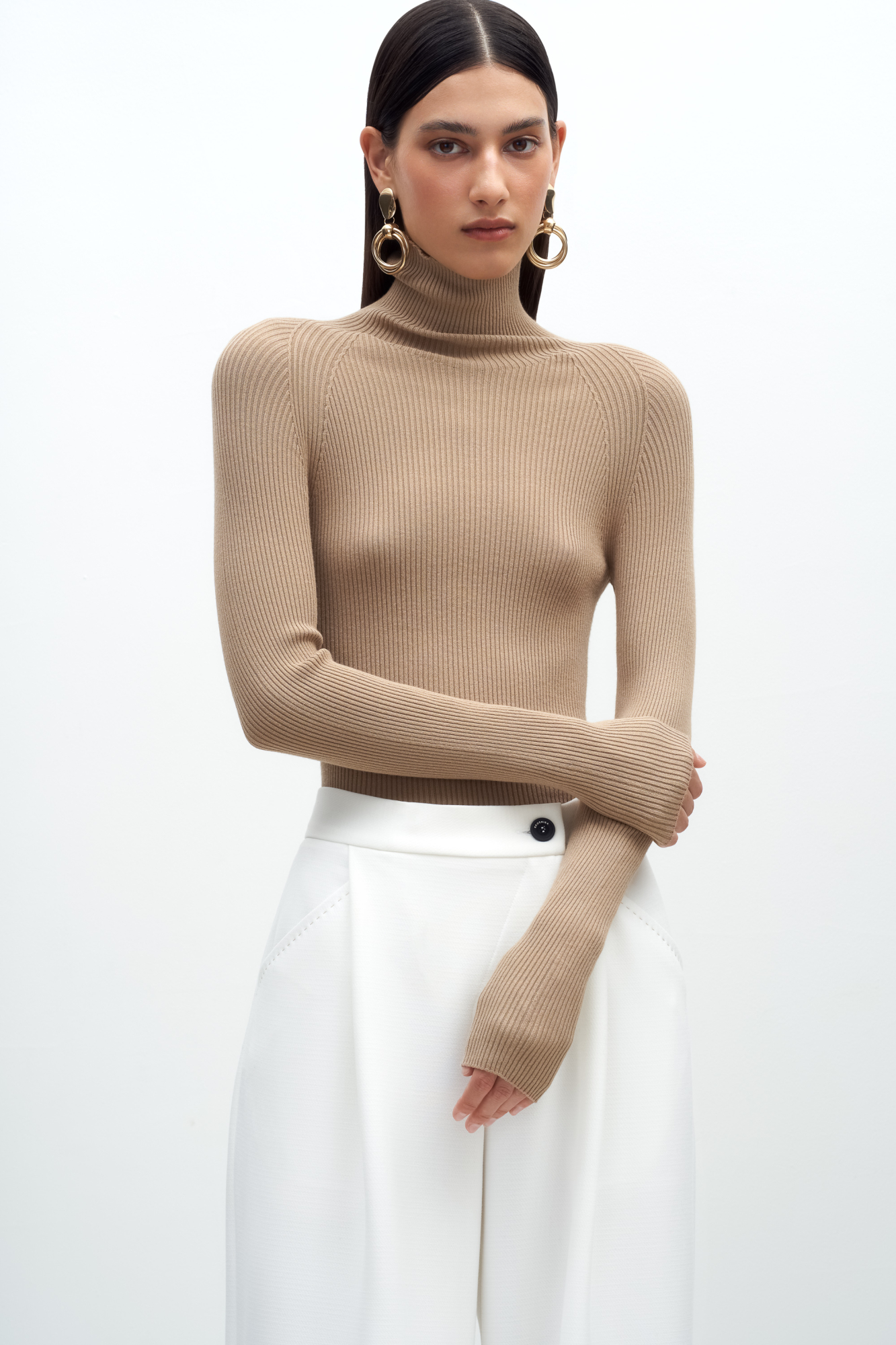 Трикотажная бесшовная водолазка из эластичной вискозы. Модель приталленого силуэта, с высоким воротником-стойкой и длинными рукавами. Изделие выполнено в рубчик.