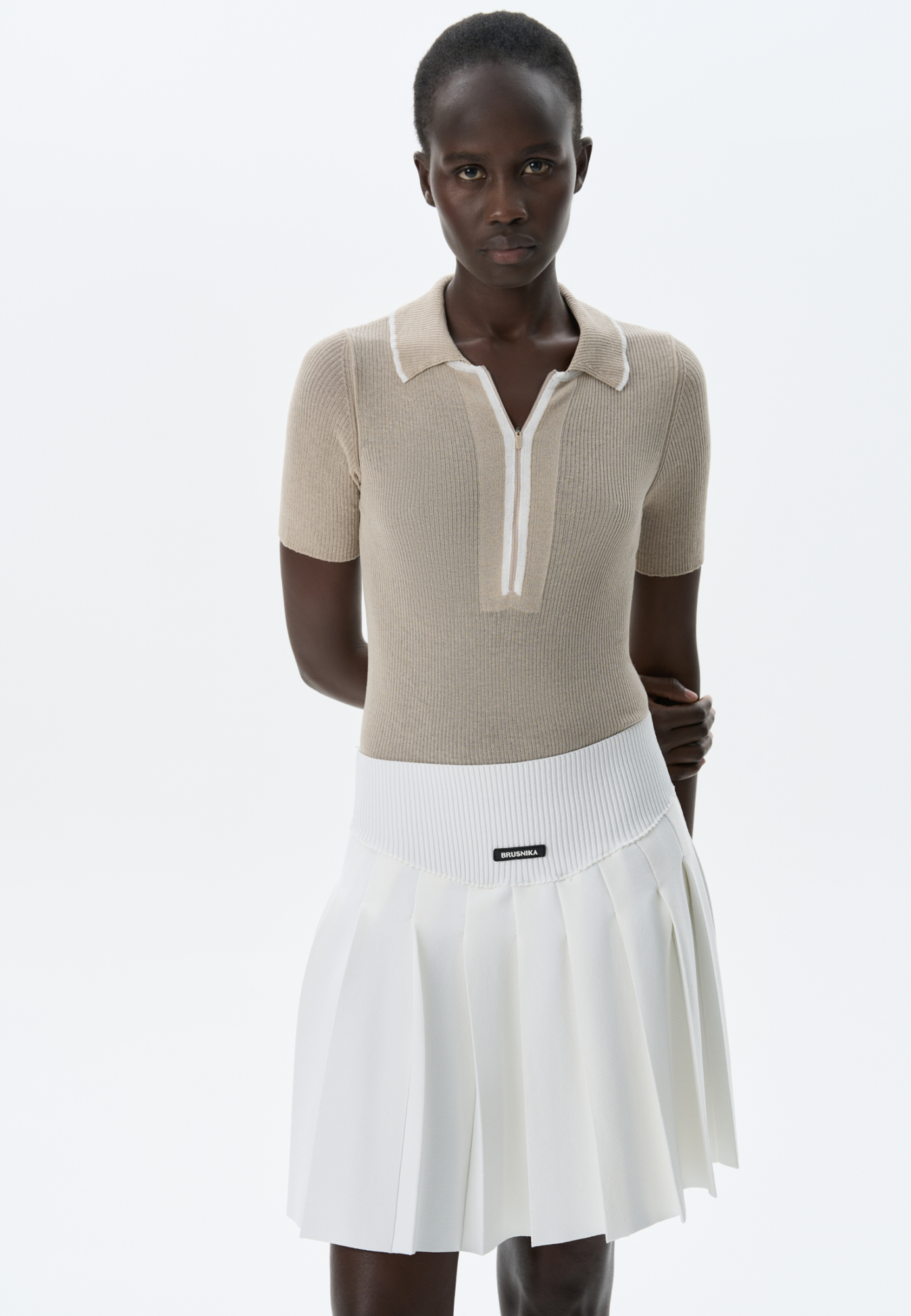 Трикотажная футболка-поло из 100% хлопка. Модель приталенного силуэта, с коротким рукавом, отложным воротником и застежкой на потайную молнию. Изделие декорировано бежевой отделкой на воротнике и вдоль планки.