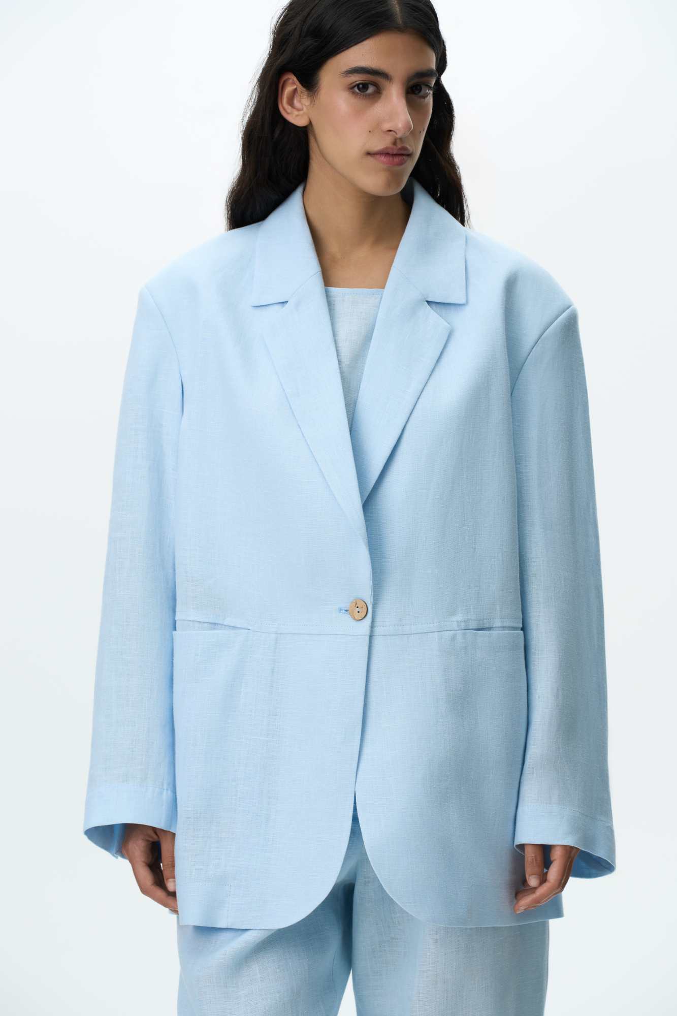 Однобортный жакет из 100% льна. Модель свободного силуэта с англиским воротником и прорезными карманами спереди. Застежка на одну пуговицу. Дополнить образ можно брюками в таком же стиле.