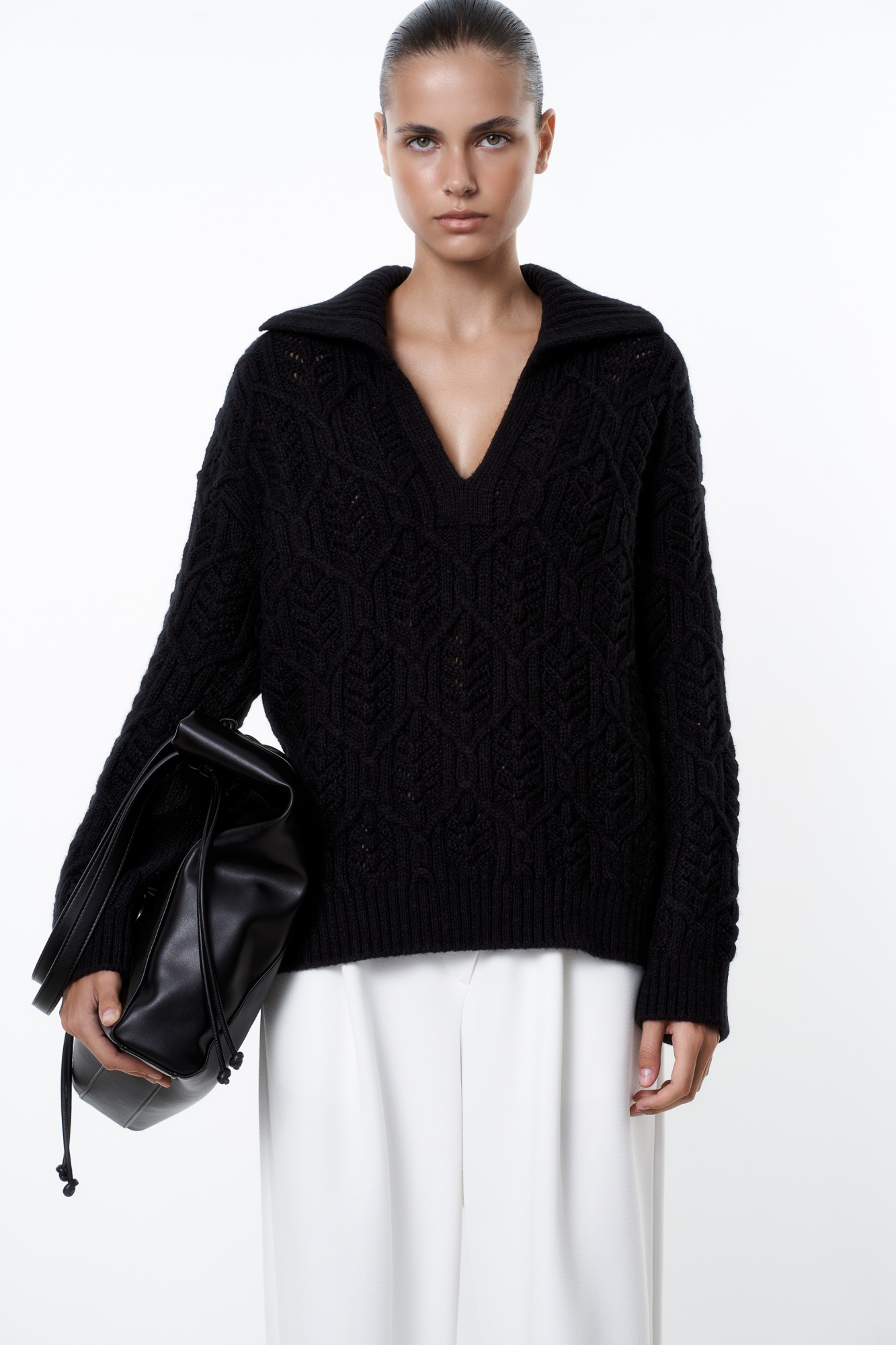 Трикотажный джемпер со сложной арнаментной вязкой с добавлением шерсти альпака. Модель свободного силуэта со спущенной линией плеча и воротником-поло с V-образным вырезом. Манжеты рукавов, воротник и низ изделия выполнен в рубчик.