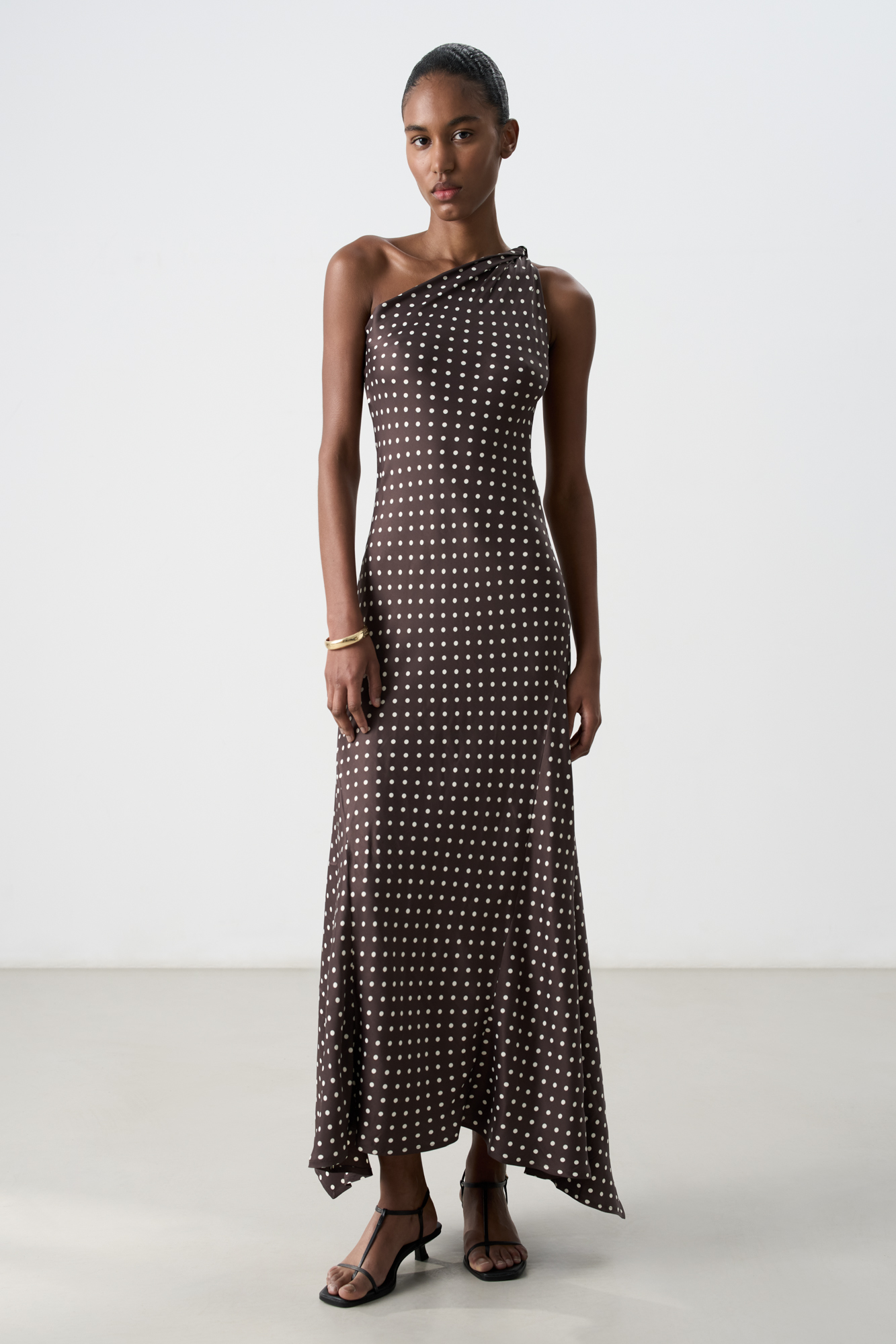 Принтованное платье длины миди из 100% вискозы. Модель приталенного силуэта, без рукавов, с перекрученной лямкой на одно плечо и слегка расклешенной, свободно струящейся юбкой.