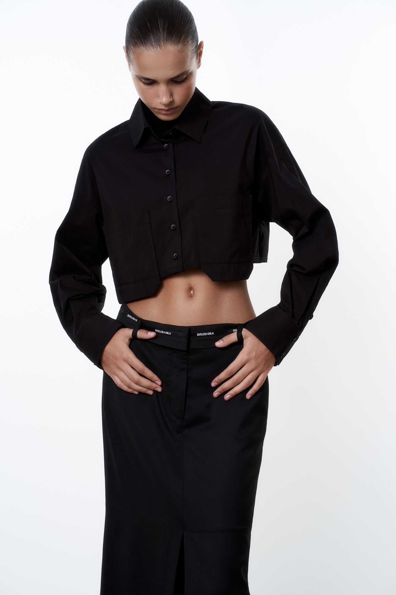 Рубашка из хлопка с добавлением полиэстера. Модель укороченного силуэта, с классическим отложным воротником, длинными рукавами и двумя накладными карманами на груди. Застежка на пуговицы. Имитация необработанного края.