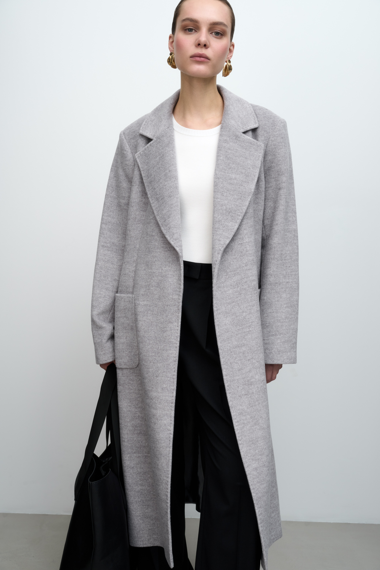 Классическое шерстяное пальто с поясом из основной ткани. Модель приталенного силуэта. Отложной воротник с прямоугольными лацканами и накладные карманы.